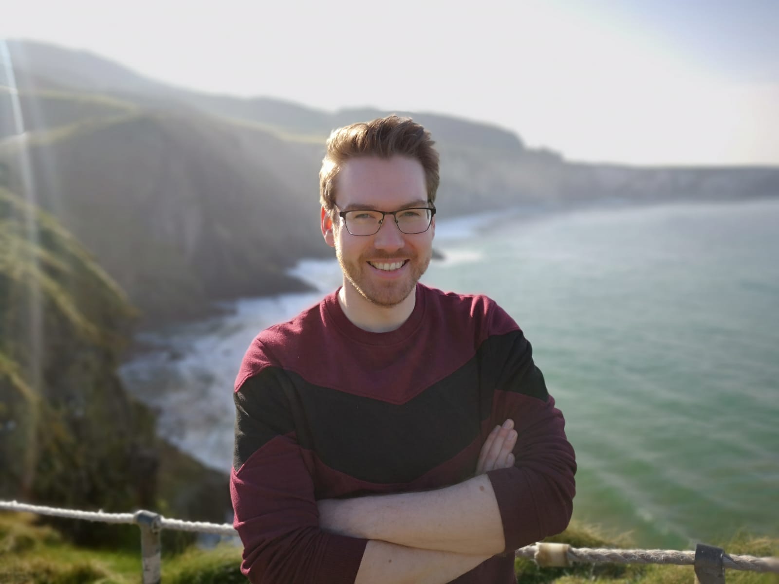 Man with crossed arms in from of panoramic sea coastal view