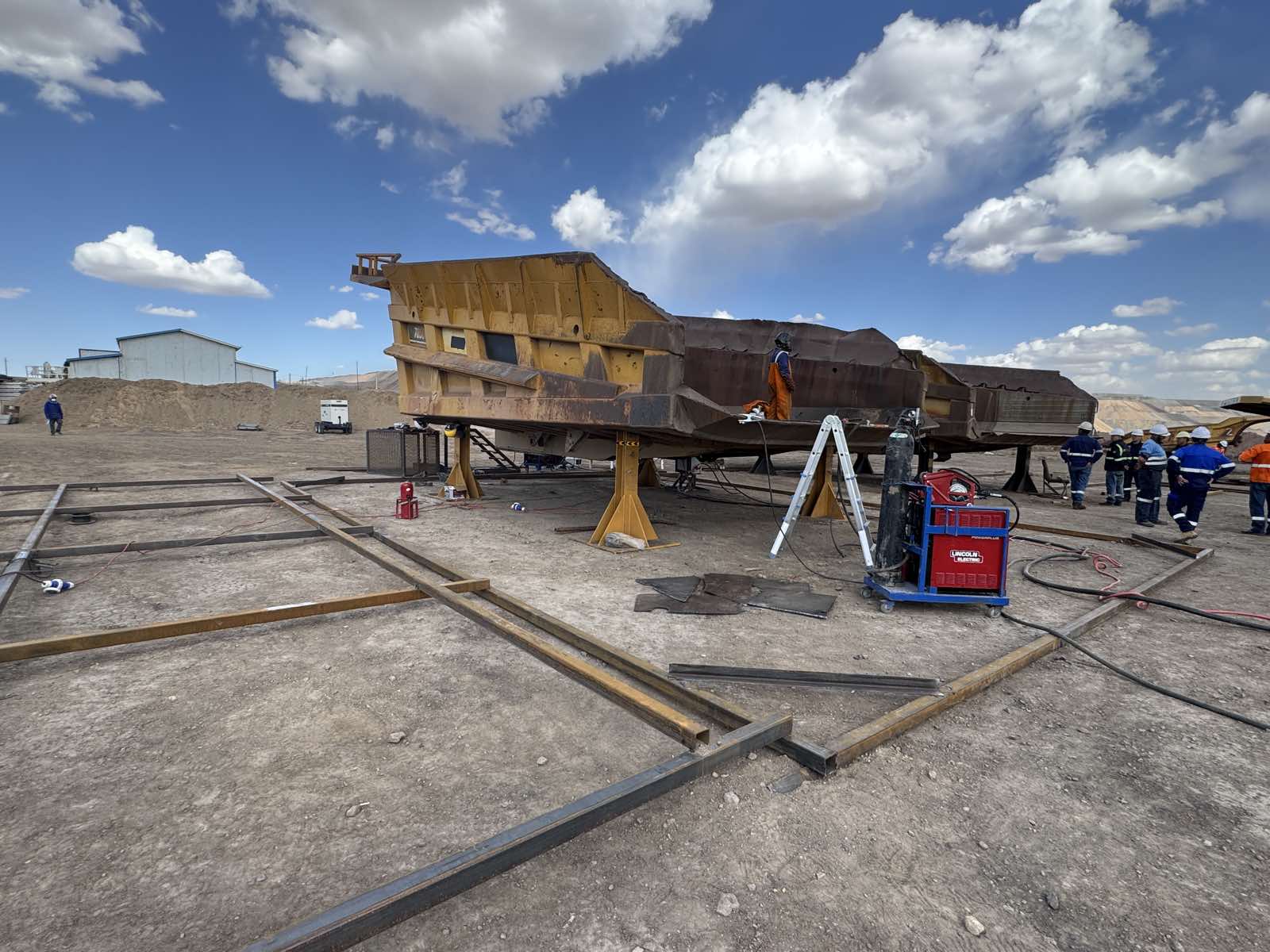 Mining heavy equipment dump truck body under aftermarket repair.