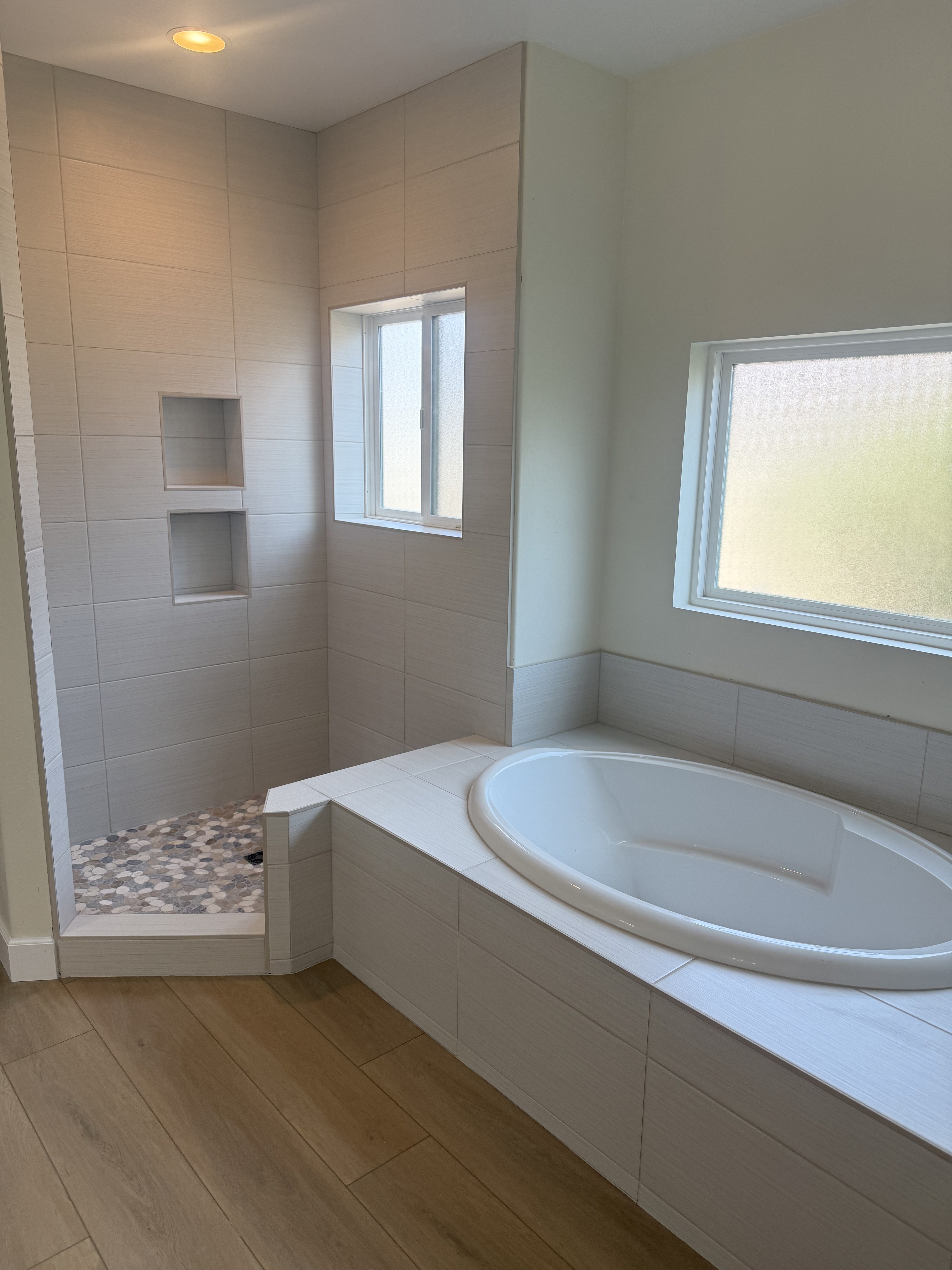 Luxurious bathroom vanity area with a dramatic wall featuring large format natural stone tiles in varying earthy tones and complex veining, serving as a striking backsplash above a double sink vanity.