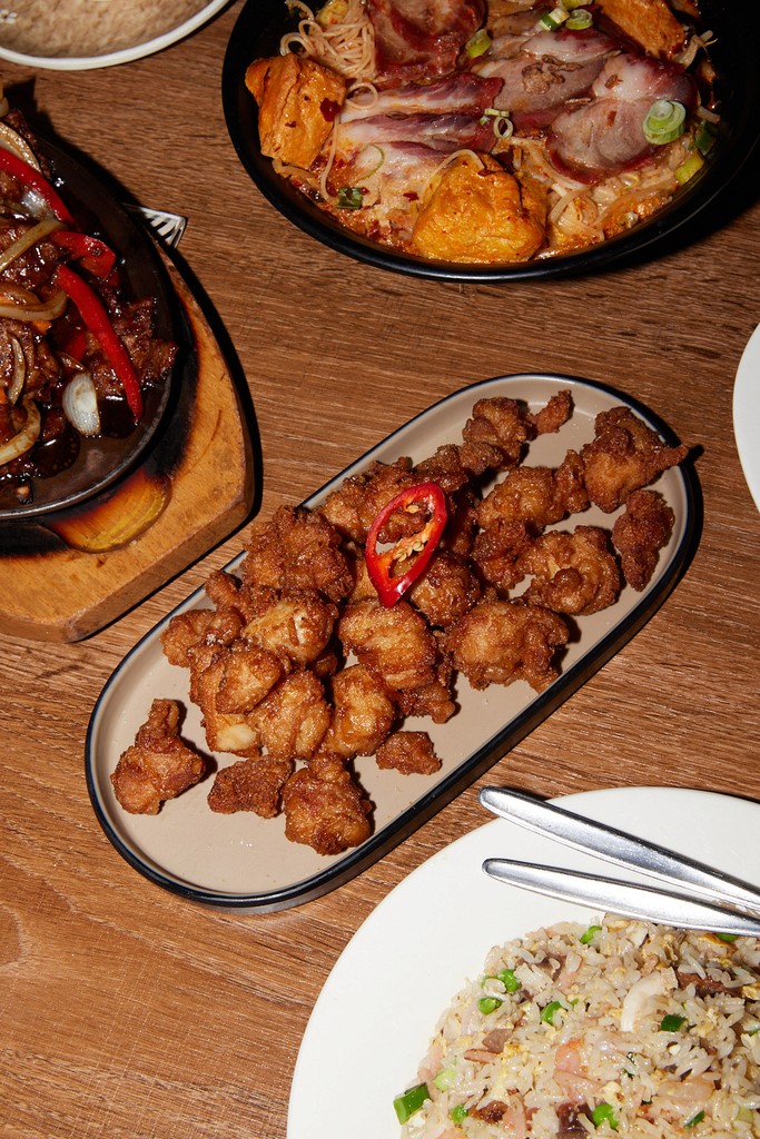 a glass of cocktail with a slime orange fruit