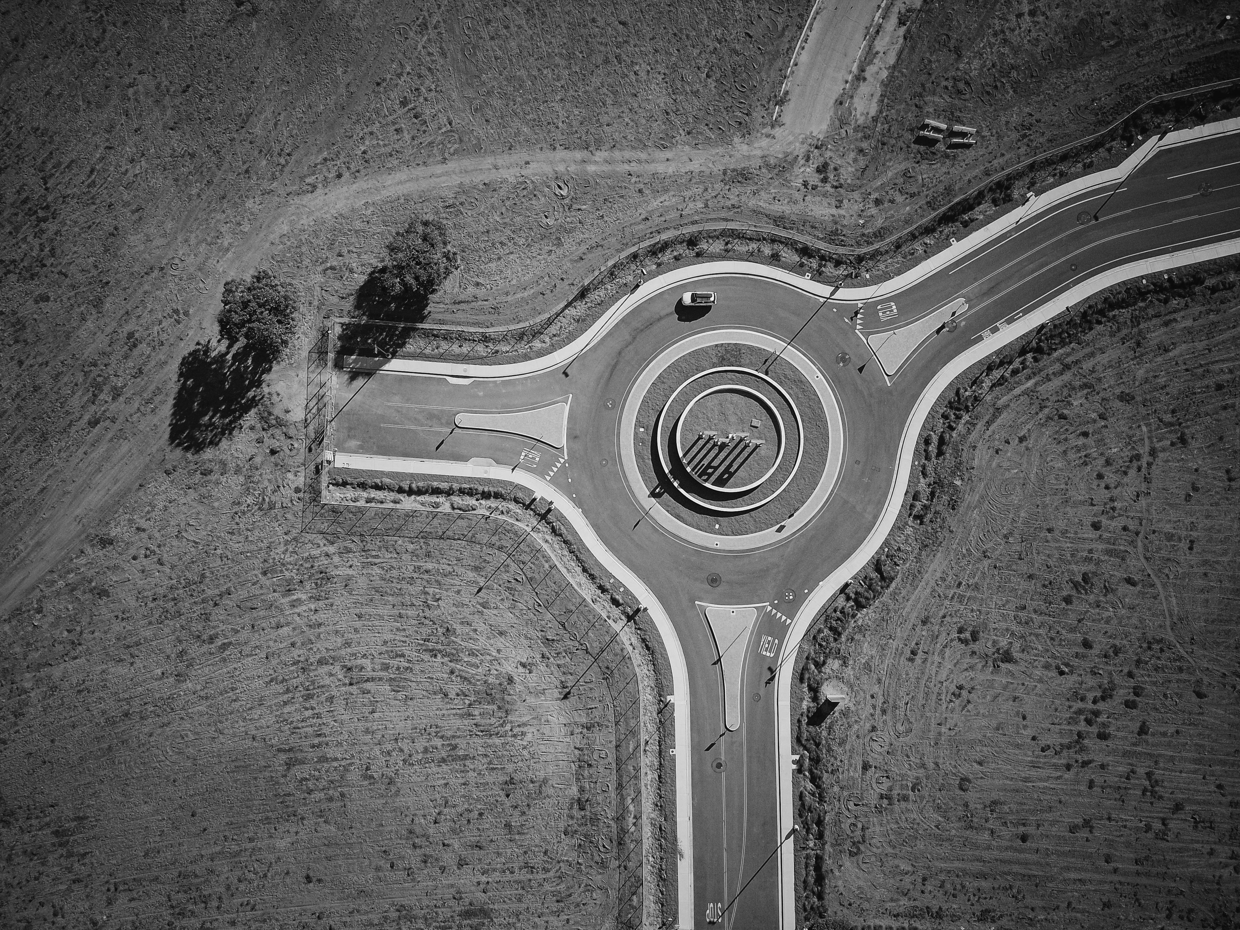 Black futuristic drone under spotlight in gray room.