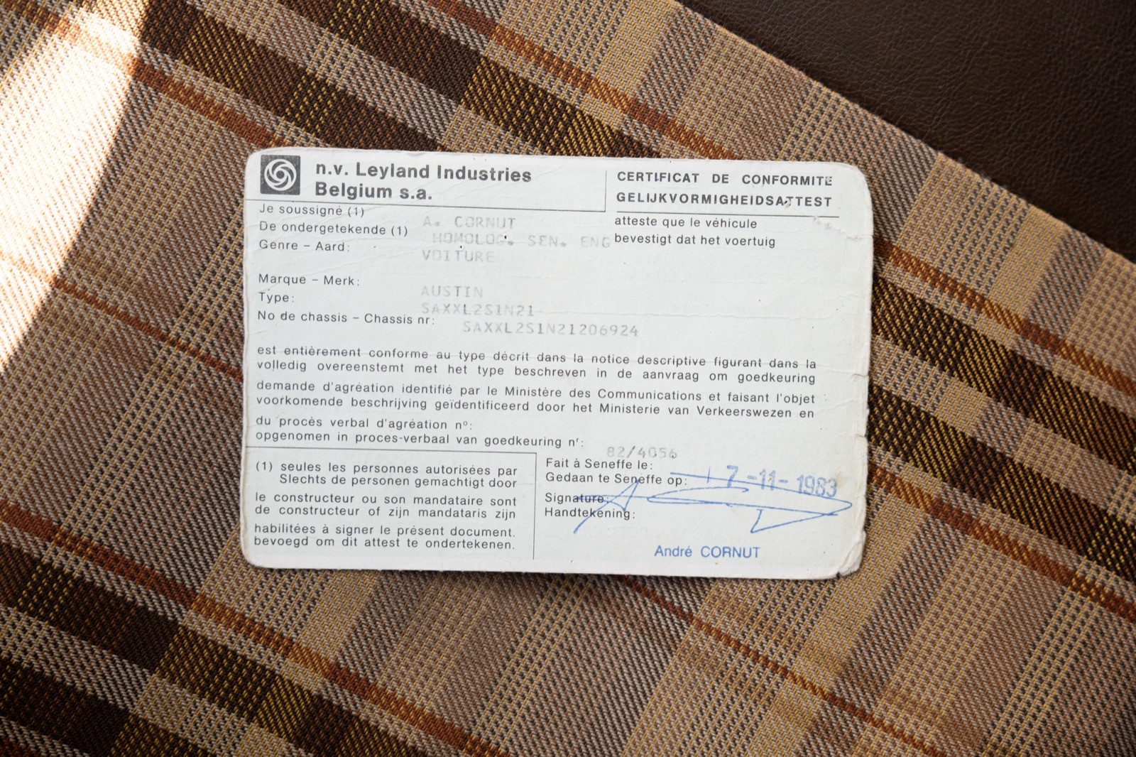A close-up of a white card with printed text, placed on a brown striped surface.