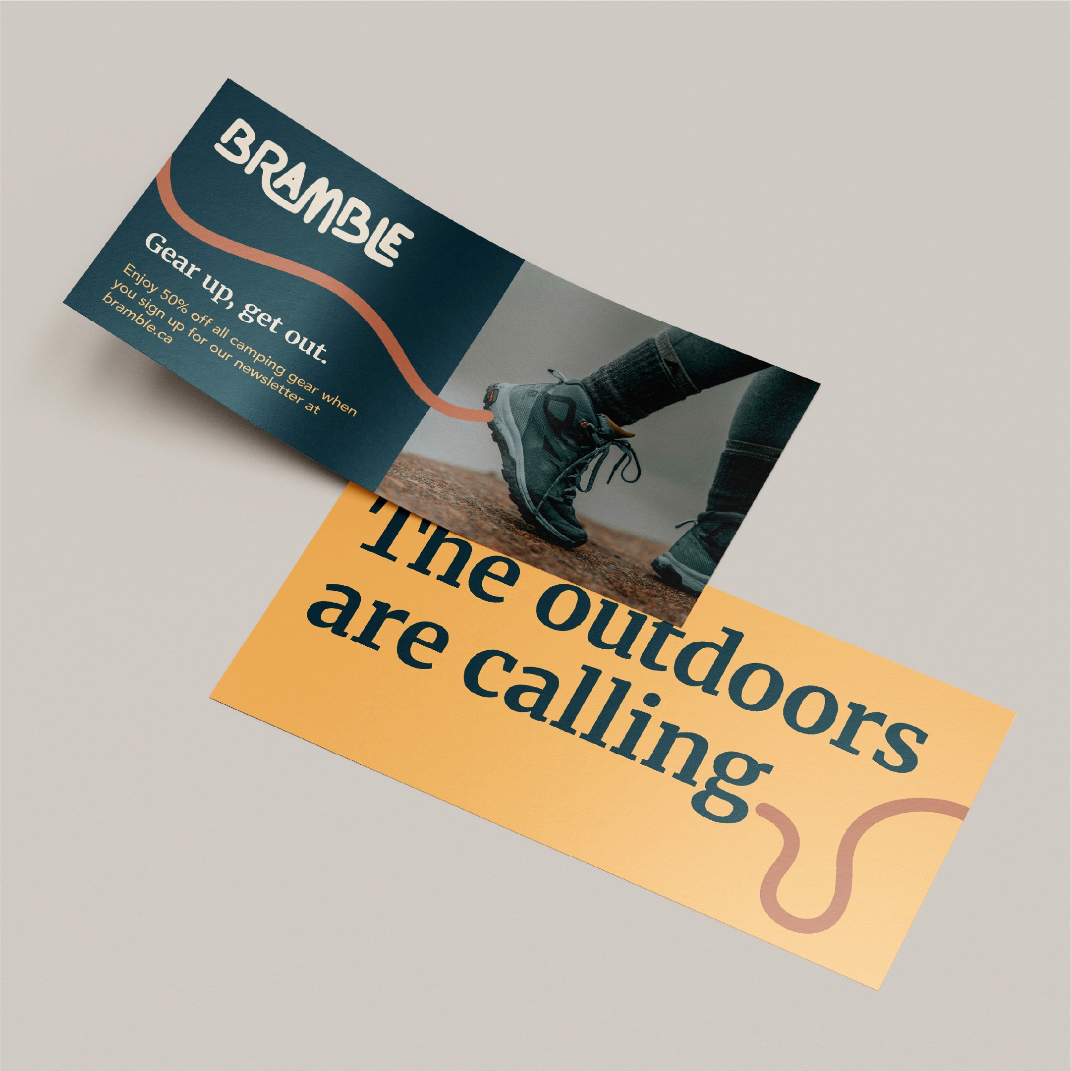 Two marketing leaflets for the outdoor brand Bramble are shown overlapping on a neutral gray surface, featuring a continuous wavy orange line that connects the visual elements across both pieces. The top leaflet contains a dark teal section with the white Bramble logo and the slogan "Gear up, get out," alongside a promotional offer for 50% off camping gear for newsletter subscribers. The right side of this leaflet displays a photograph of a person wearing rugged hiking boots on rocky terrain. The bottom leaflet features a warm orange-to-yellow gradient background with the bold teal headline "The outdoors are calling," while the wavy orange line continues into the corner to form a looped, trail-like shape.