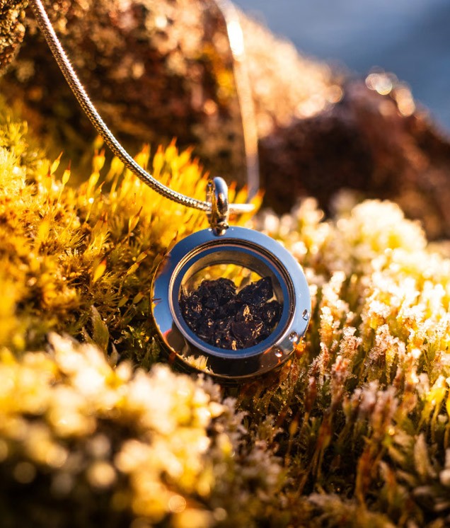 A handcrafted obsidian necklace, produced by Lava Show, displayed on a black bust. Made from real volcanic glass formed by rapidly cooling rhyolite lava, this striking piece is one of the exclusive products available at the Lava Show.