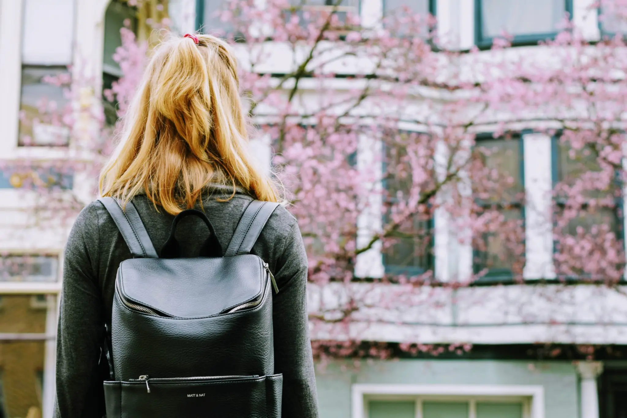 Student stairing at the university dorm building from a distance