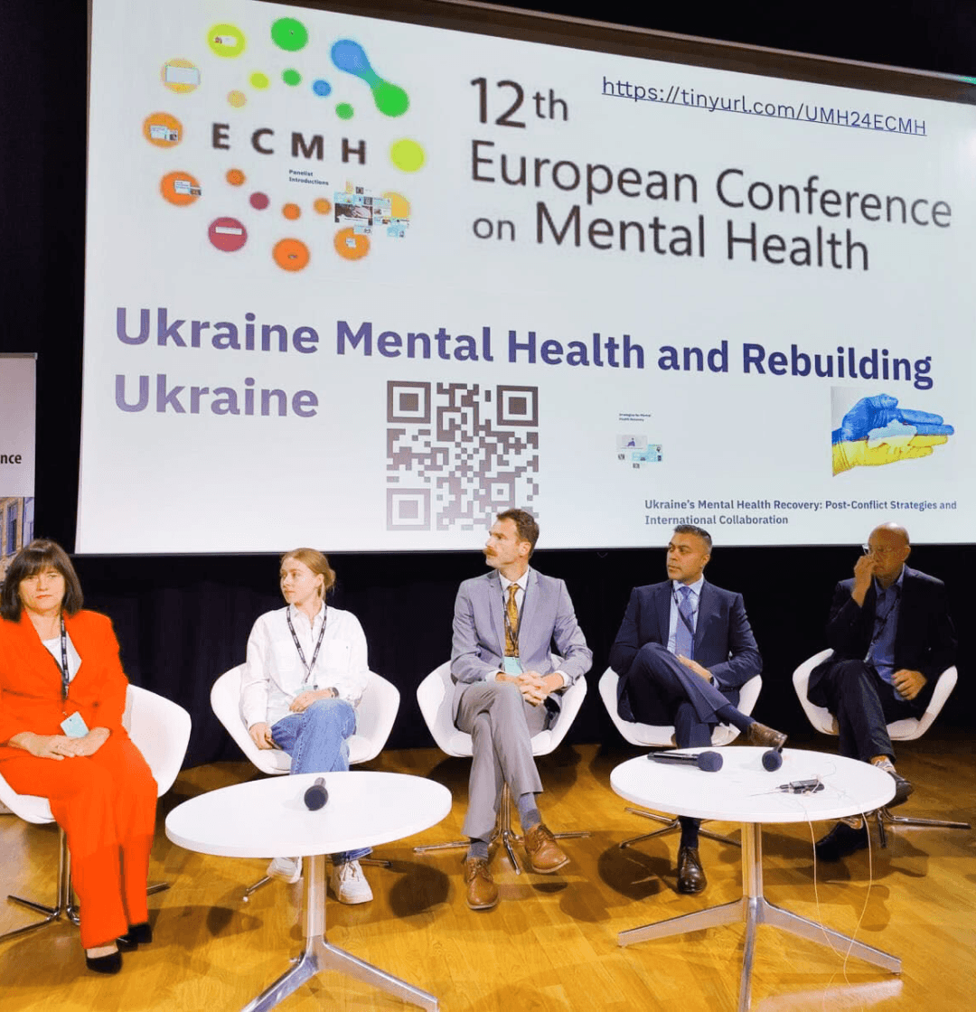 Panelists speaking during the European Conference on Mental Health 2024, with a banner behind them highlighting Ukraine’s mental health and resilience initiatives.