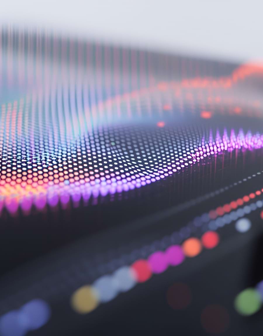 Abstract digital art with vibrant, multicolored dots forming undulating wave patterns on a dark background, conveying a dynamic and futuristic feel.