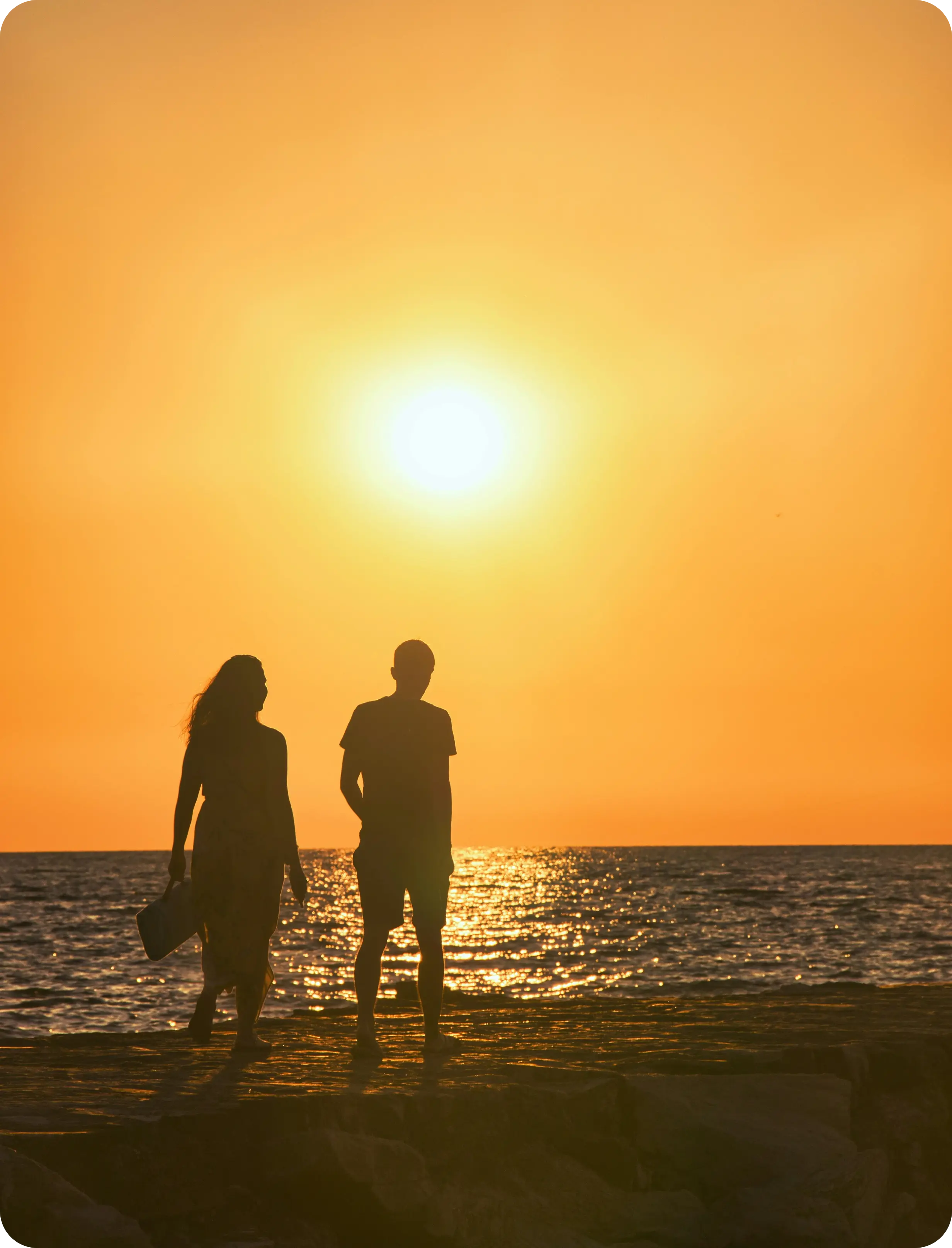 a couple of people standing on top of a beach