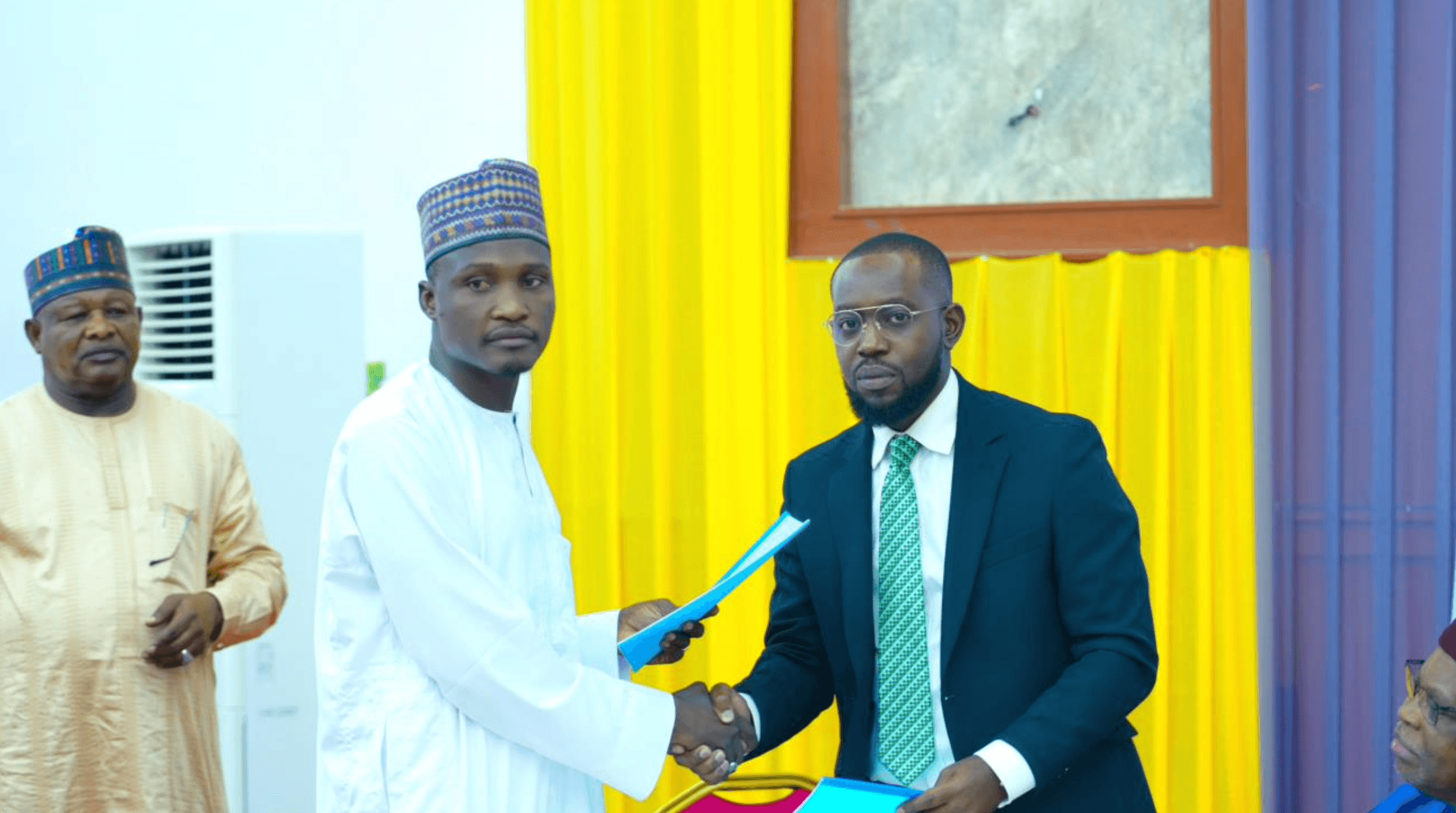 Engr. Bamodu Yerima, Managing Director, Yobe Mining Development Company Limited (YMDCL), and Damiete Amachree, Managing Director, GeoScan Technology Limited, exchange documents after signing the Memorandum of Understanding in Damaturu.
