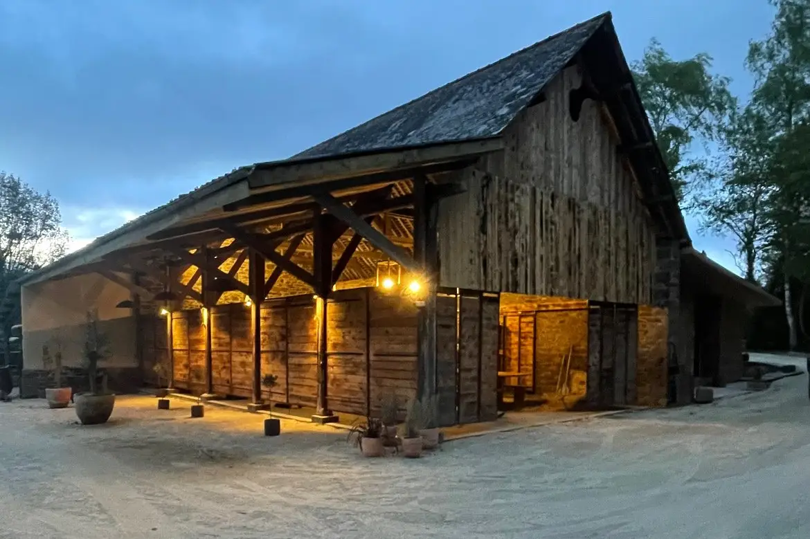 A couple dances closely, showcasing a flowing green dress, against a soft, blurred background of other guests.