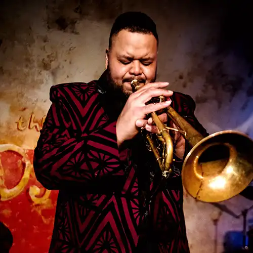 Jumaane Smith Singing and holding his trumpet.