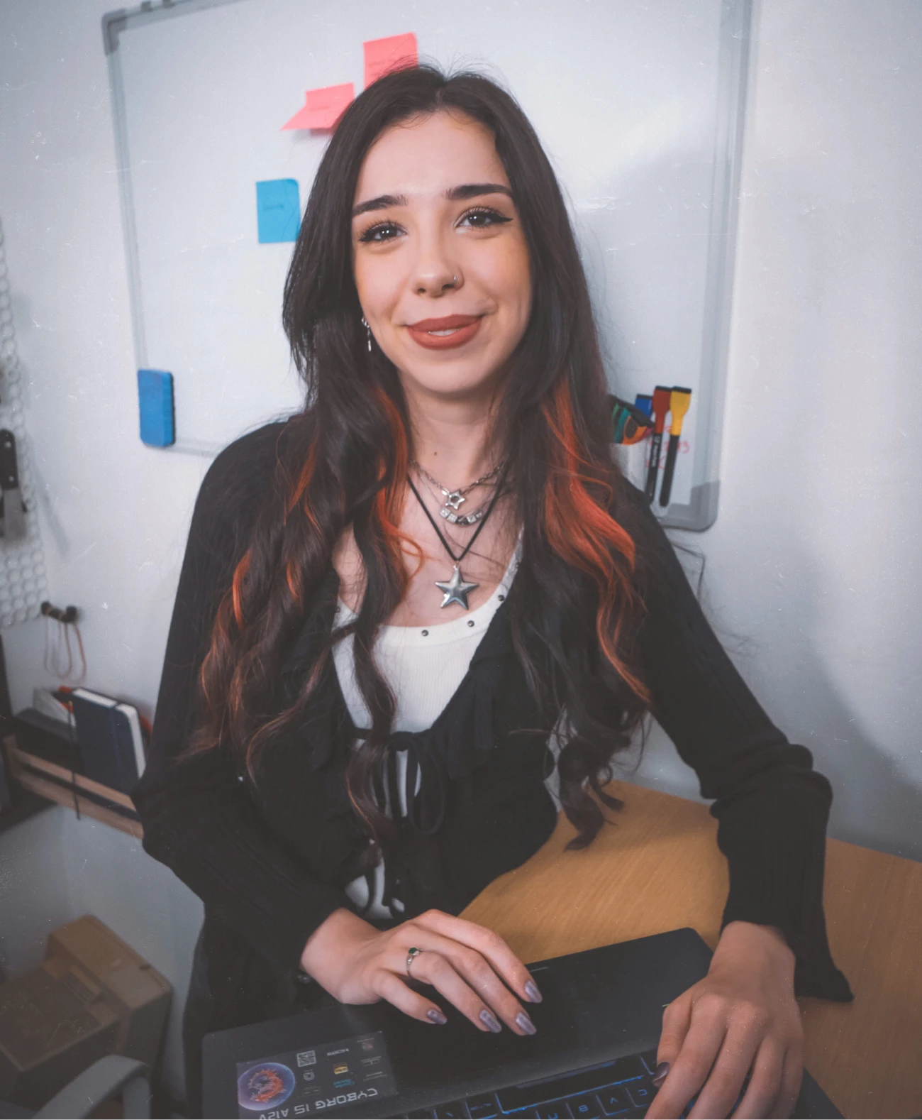 About LRNA Design - Lorena on laptop looking and smiling at the camera