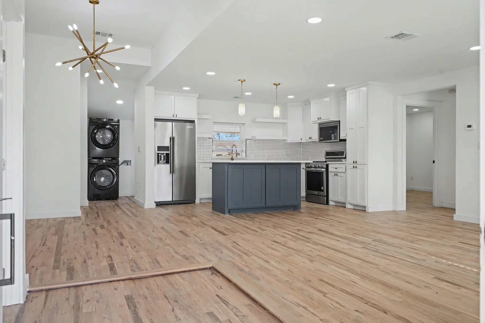 A sophisticated lounge terrace with curved white stucco walls, stone seating, and arched cutouts perfectly framing an unobstructed ocean sunset.