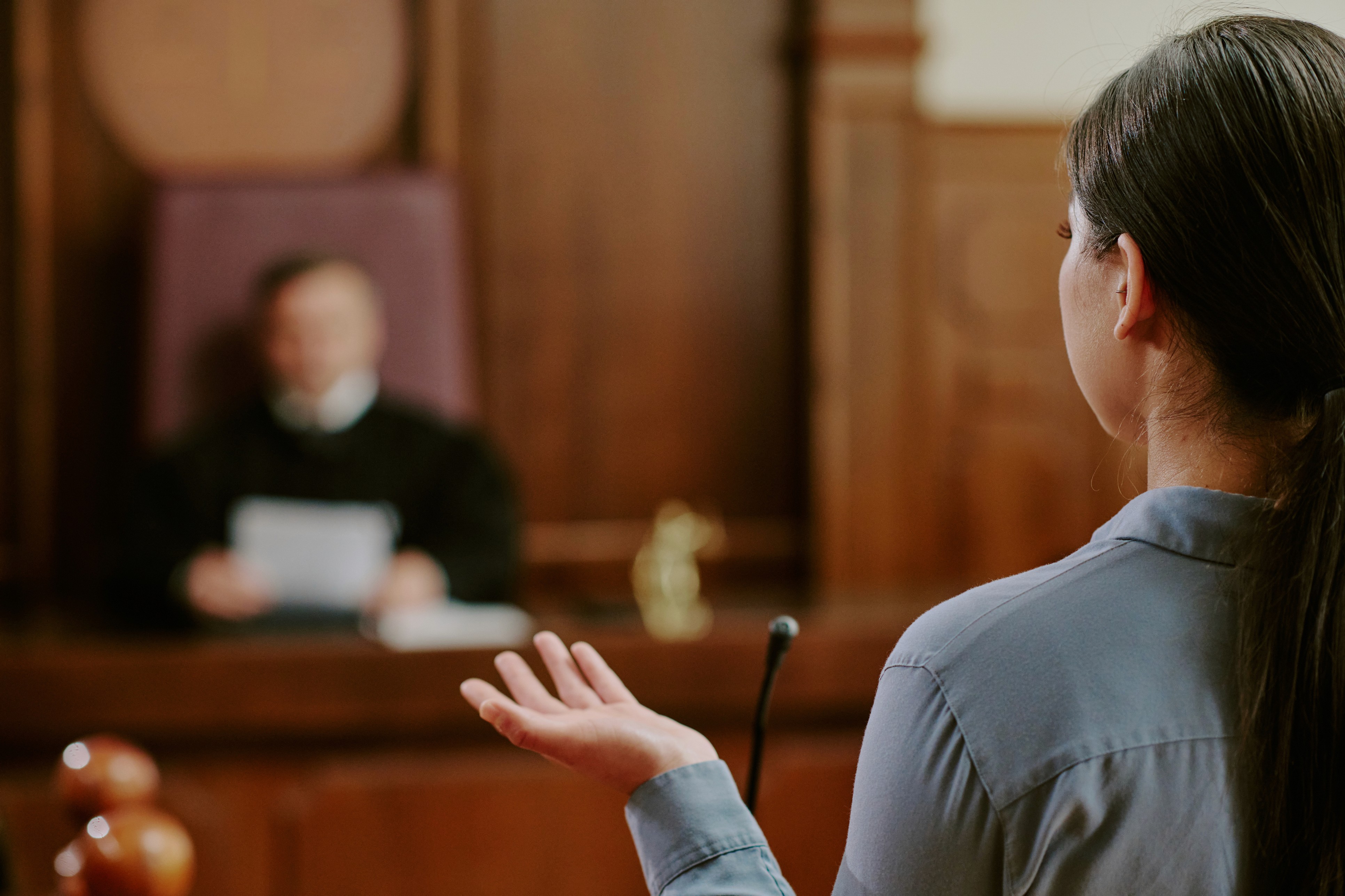 Young woman in courtroom and judge