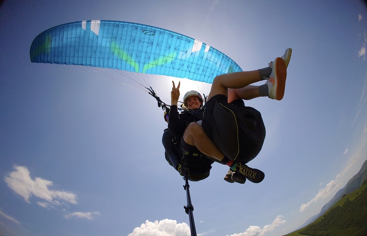man in black and white shirt sitting on green grass field near lake during daytime