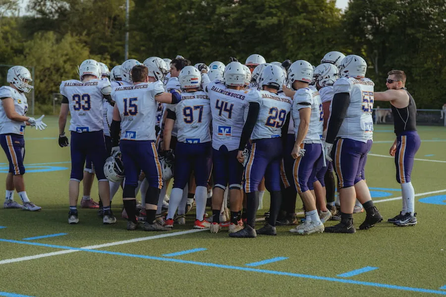 Die Spieler der Balingen Bucks in weißen Trikots stehen im Kreis auf dem Spielfeld zusammen.