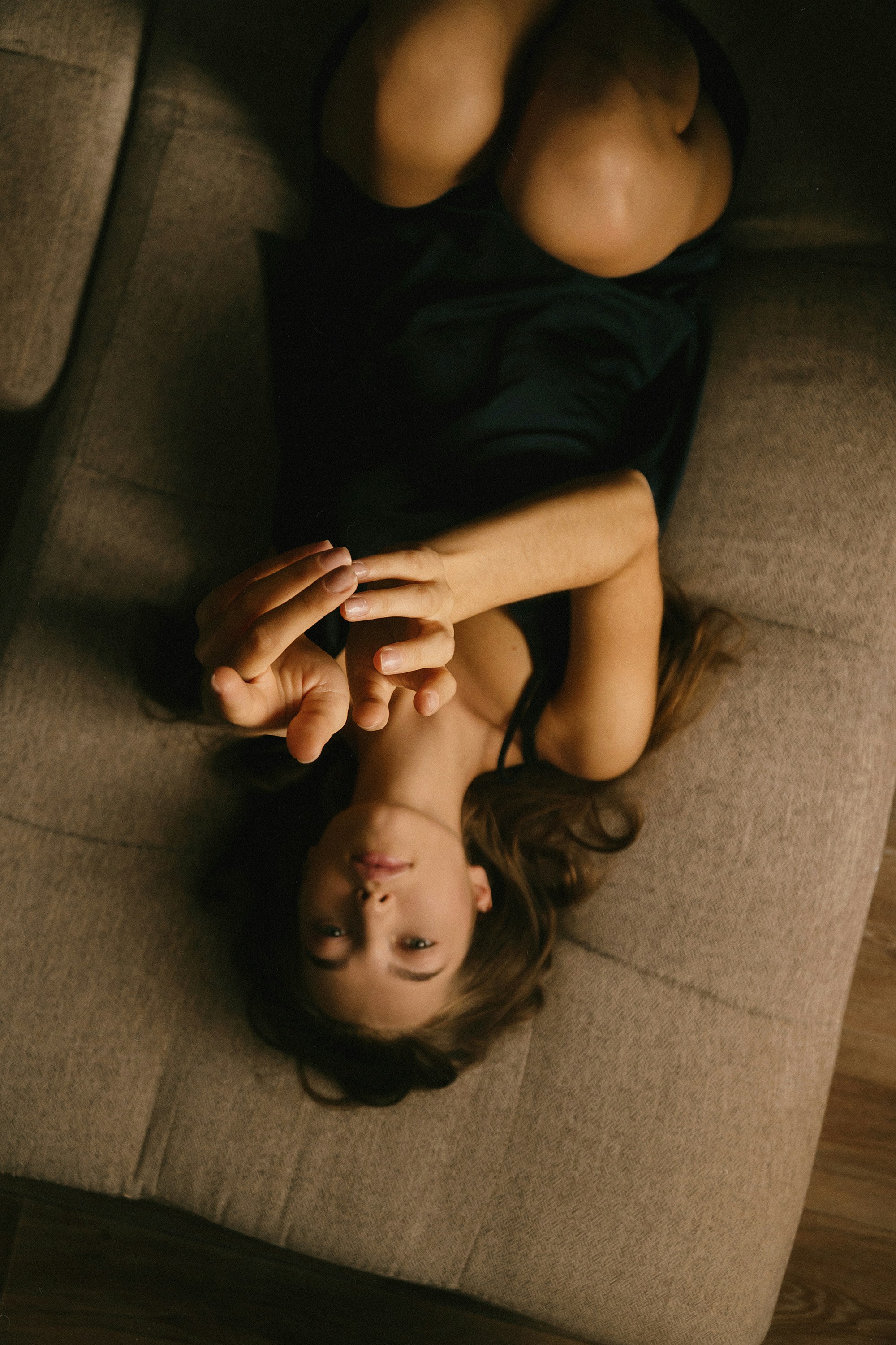 A woman laying on top of a couch next to a man