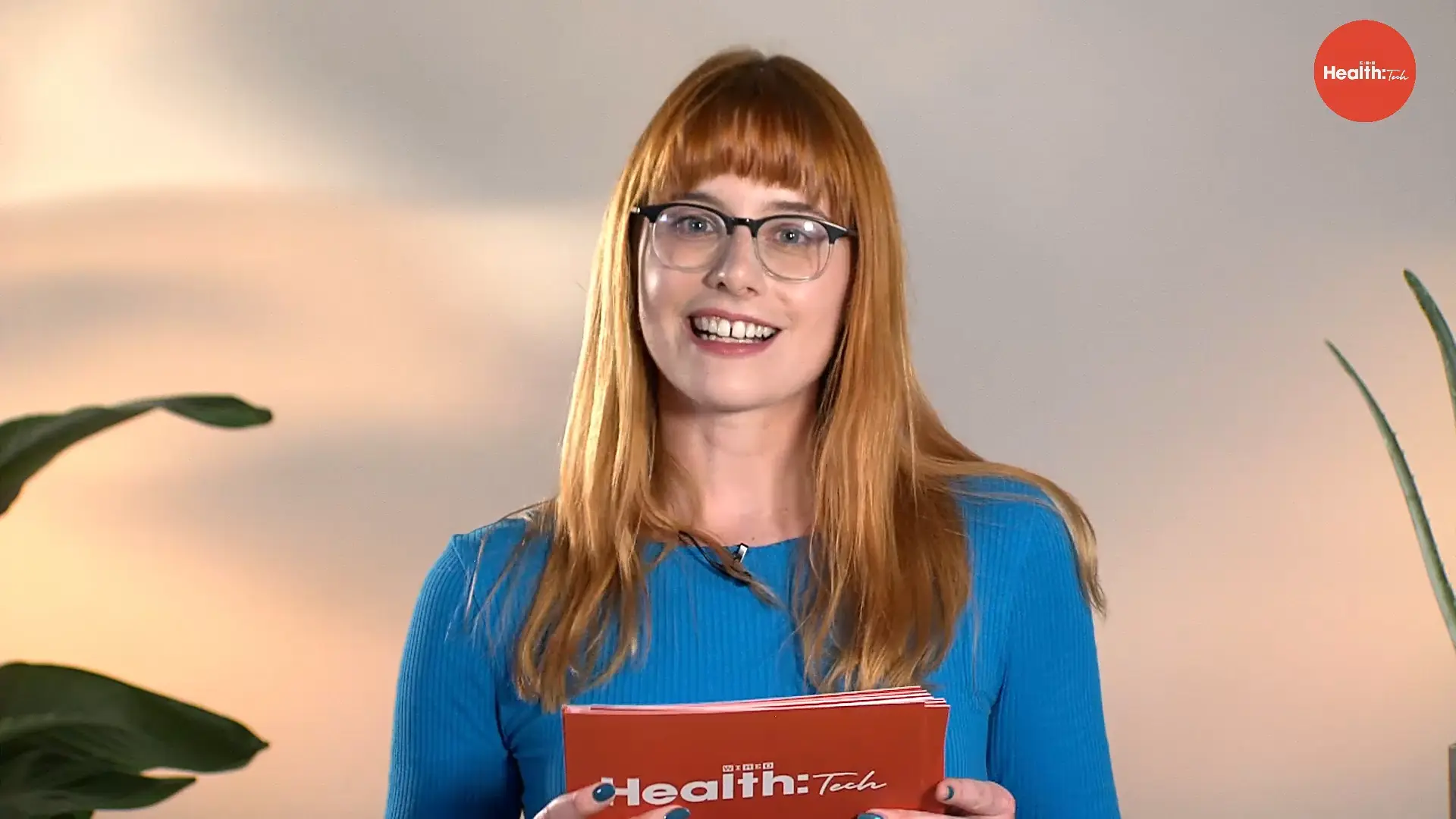 WIRED Health Tech presenter holding cue cards and addressing the camera during a live broadcast.