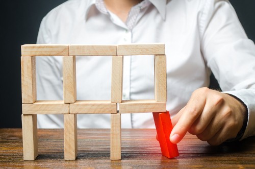 Man removing the red structural element, which will collapse.