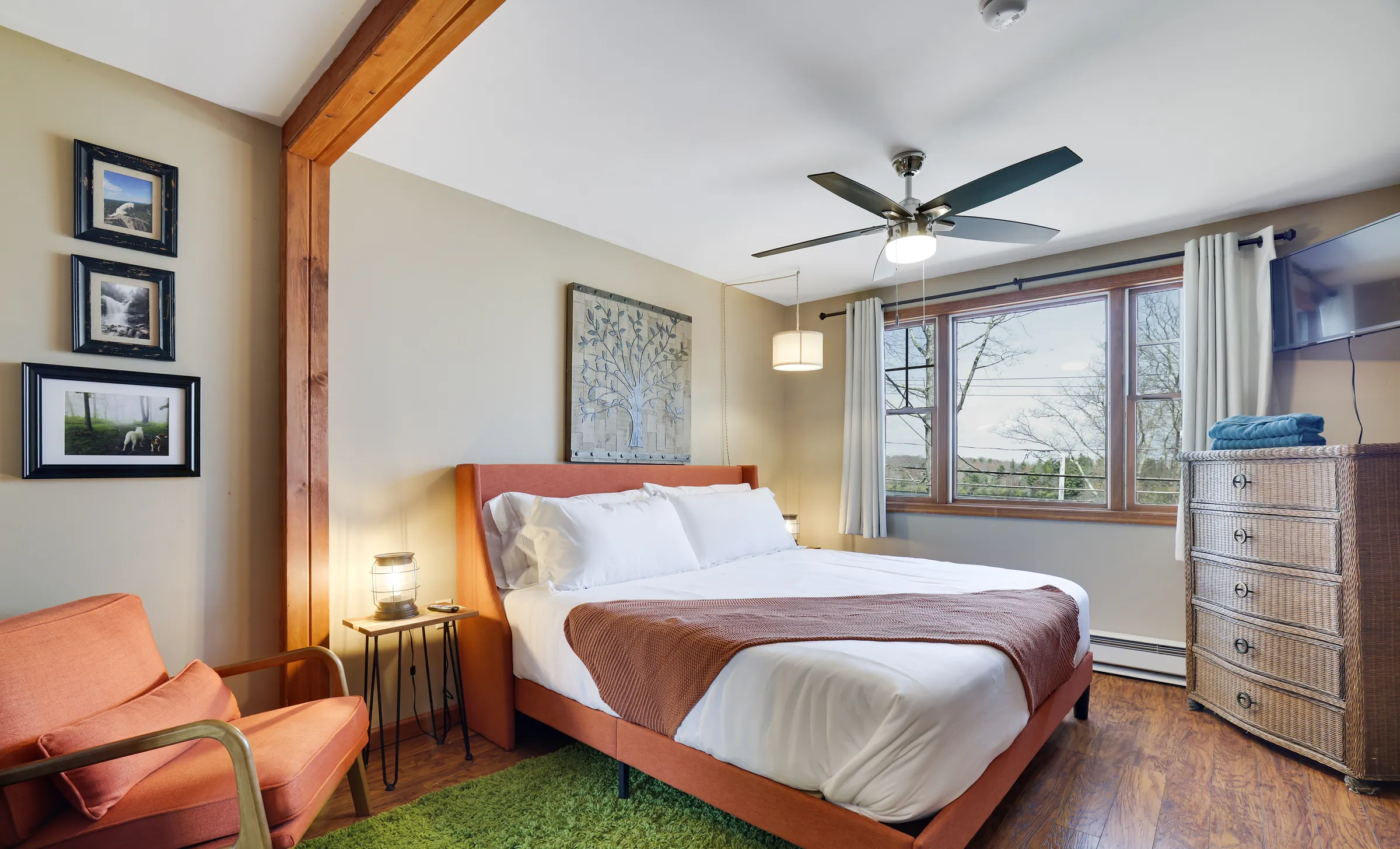 King ensuite bedroom with lake view window, chair and dresser at Laketop Lodge
