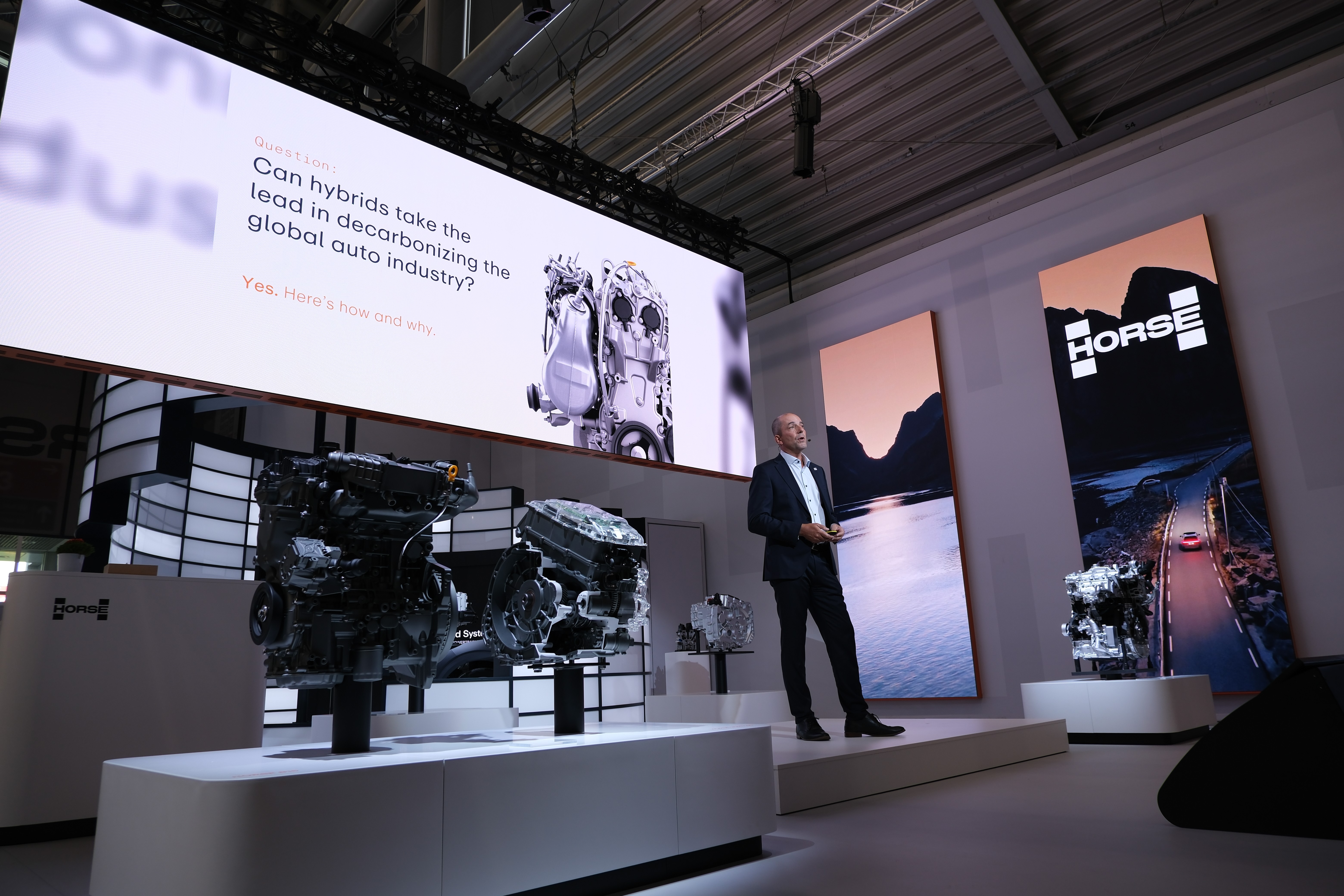 presentatör står på scenen och talar framför en publik