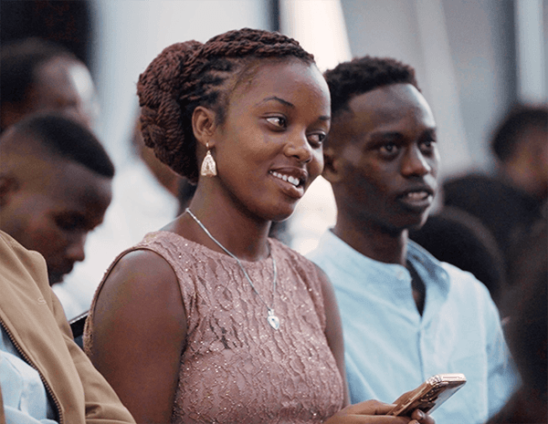 Young African woman smiling in an audience at a Chancen International event