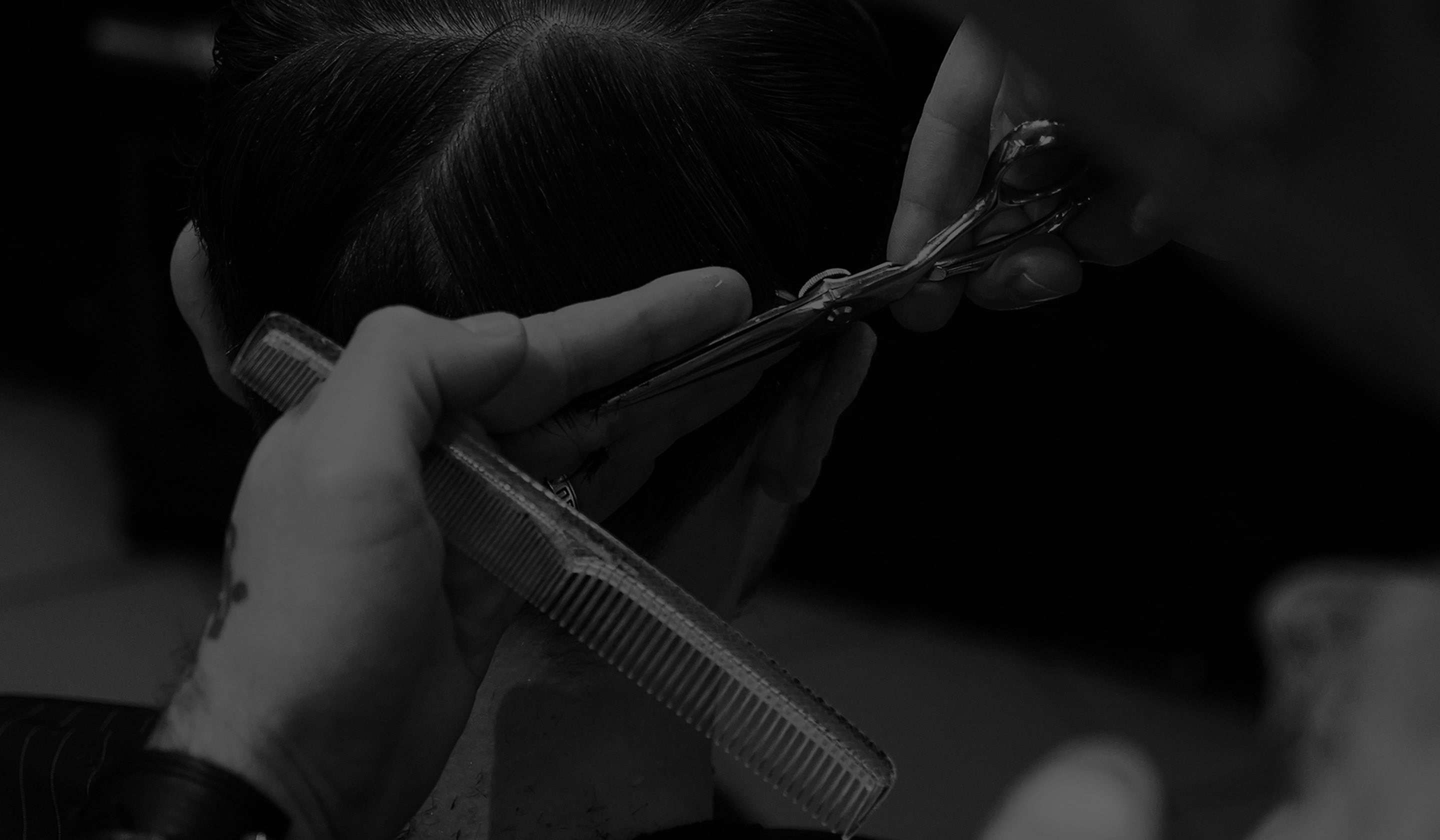 Two women on a couch pulling slices of pizza out of a box