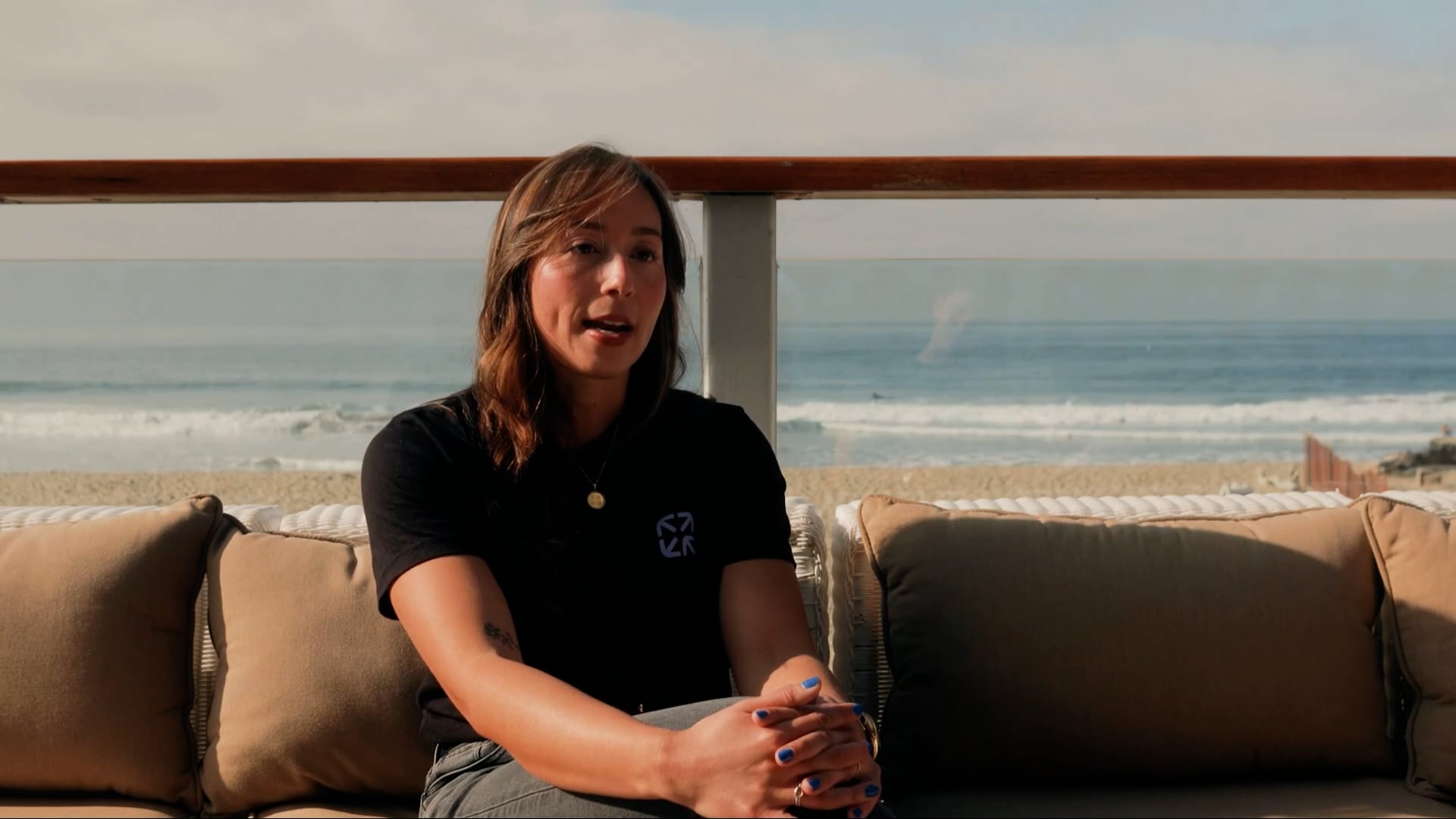 OnsiteIQ's customer success operations lead sitting on a sofa in front of the beach in Malibu.