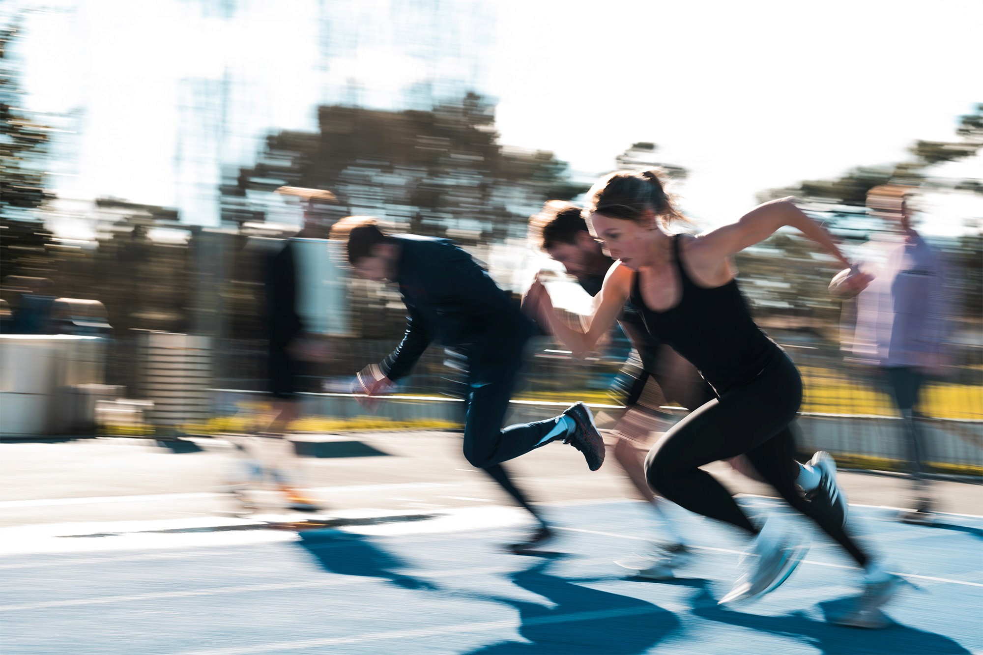 Two individuals are working out in a gym, focusing on dumbbells and strength training equipment.