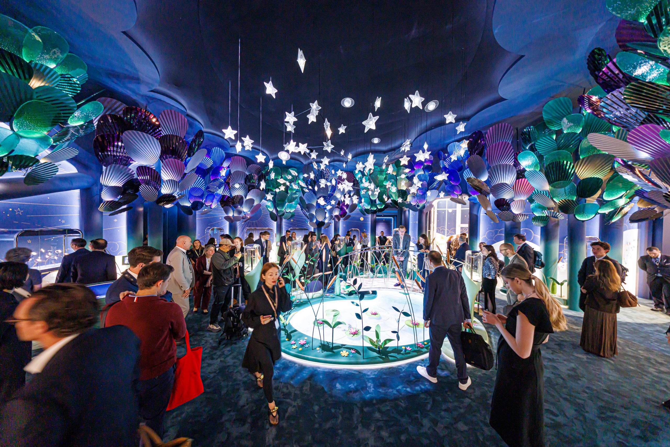 Van Cleef & Arpels booth with colorful floating installations and artistic dreamlike exhibition space