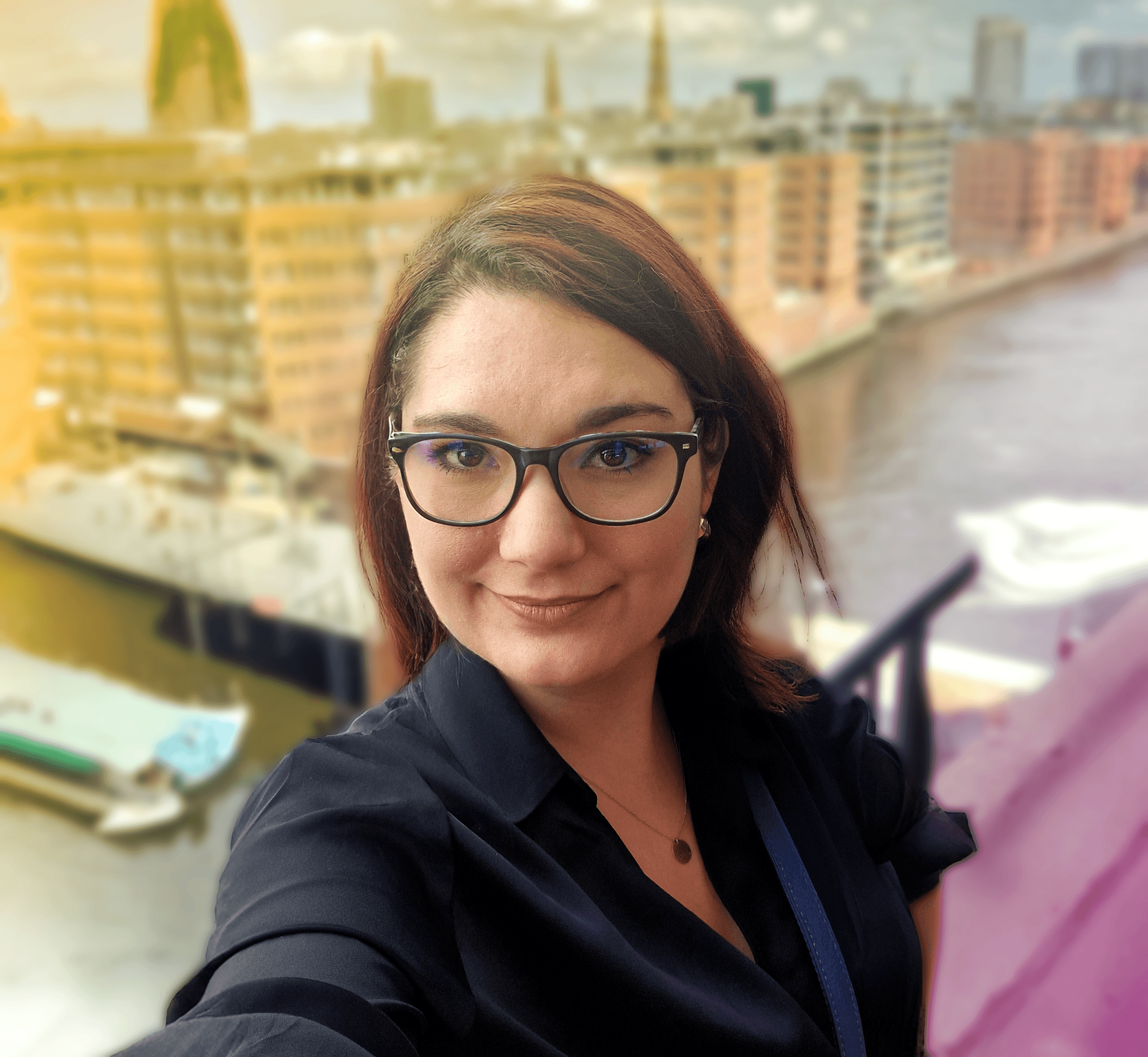Ein Bild der Erstellerin der Webseite im Portrait etwas von oben, vor einer Kulisse am Hamburger Hafen. Sie schaut freundlich in die Kamera und freut sich auf einen Kontakt.