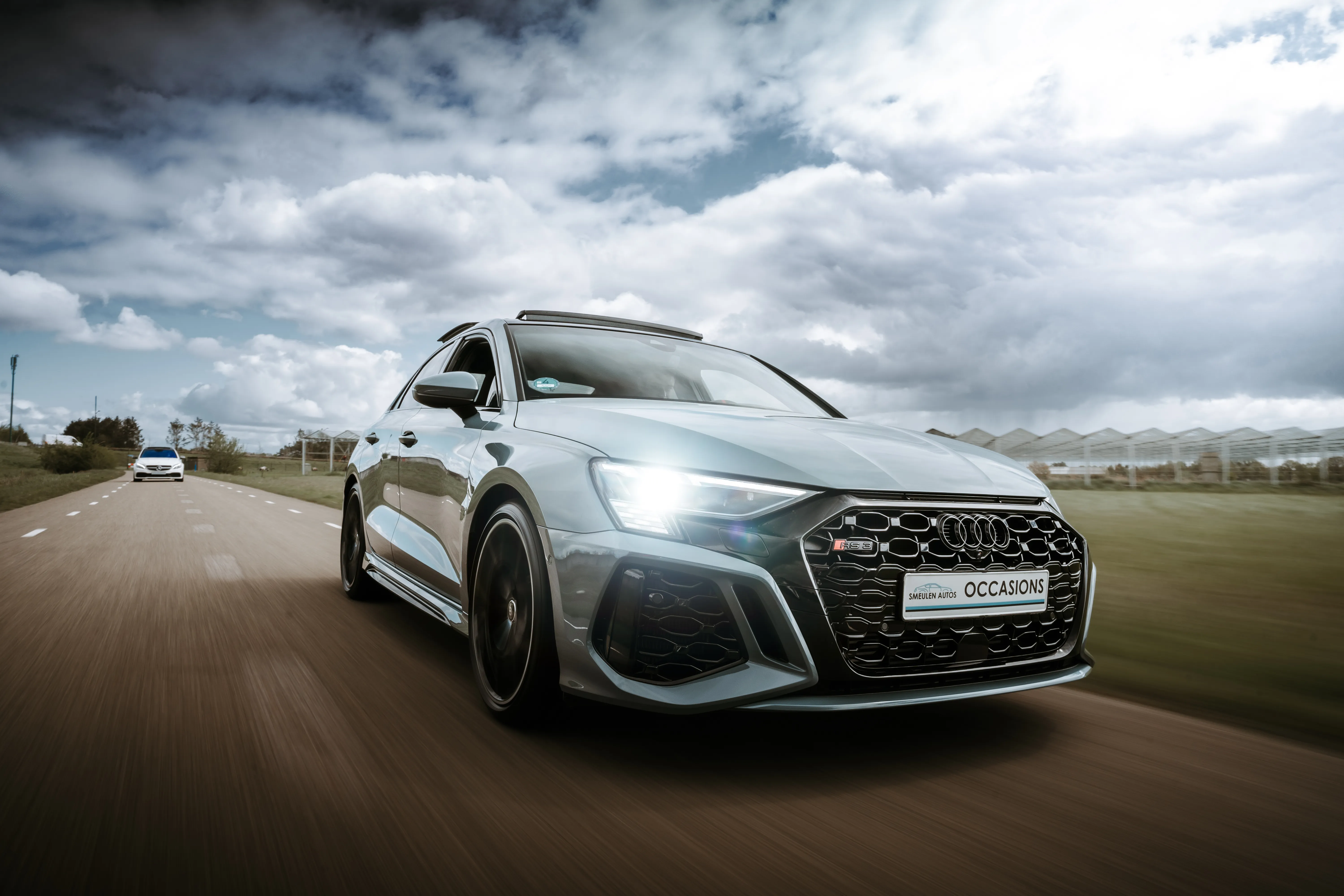 Frontside view of an Audi driving fast on a country road