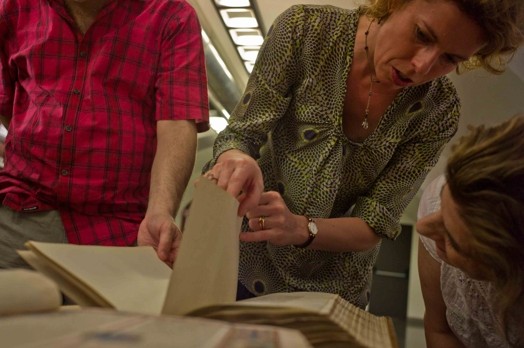 a woman looking through a old book
