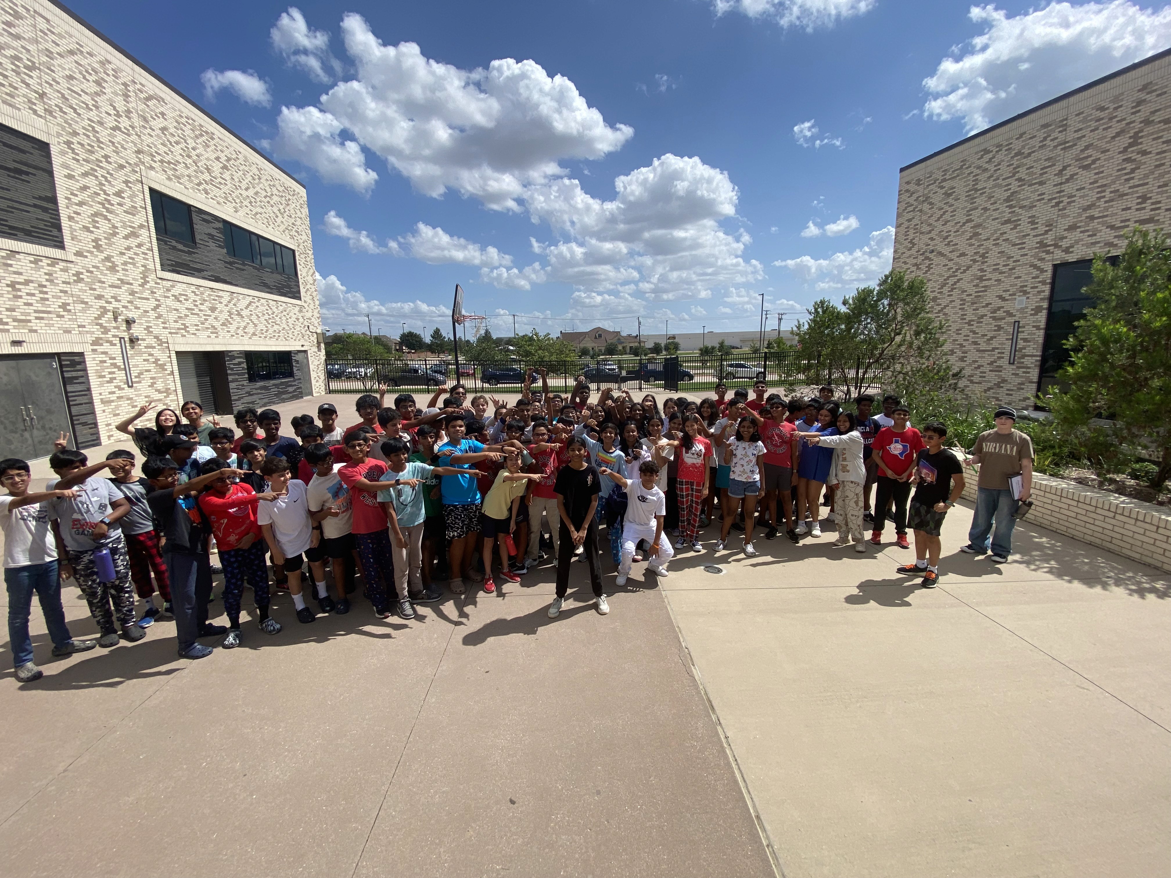 Full band group photo outside the school