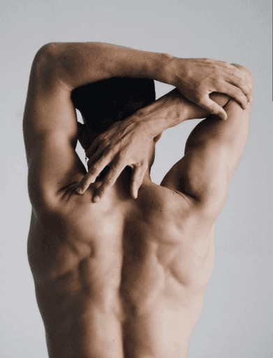 topless man in black shorts bending over