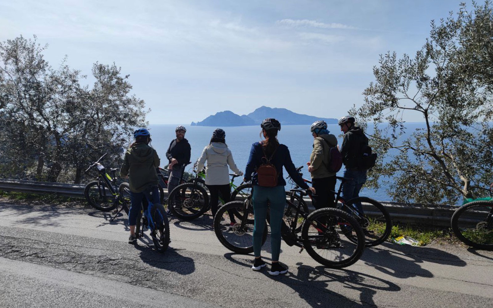 在索伦托出发的维苏威火山之旅中,一群人在海边骑电动自行车观光。