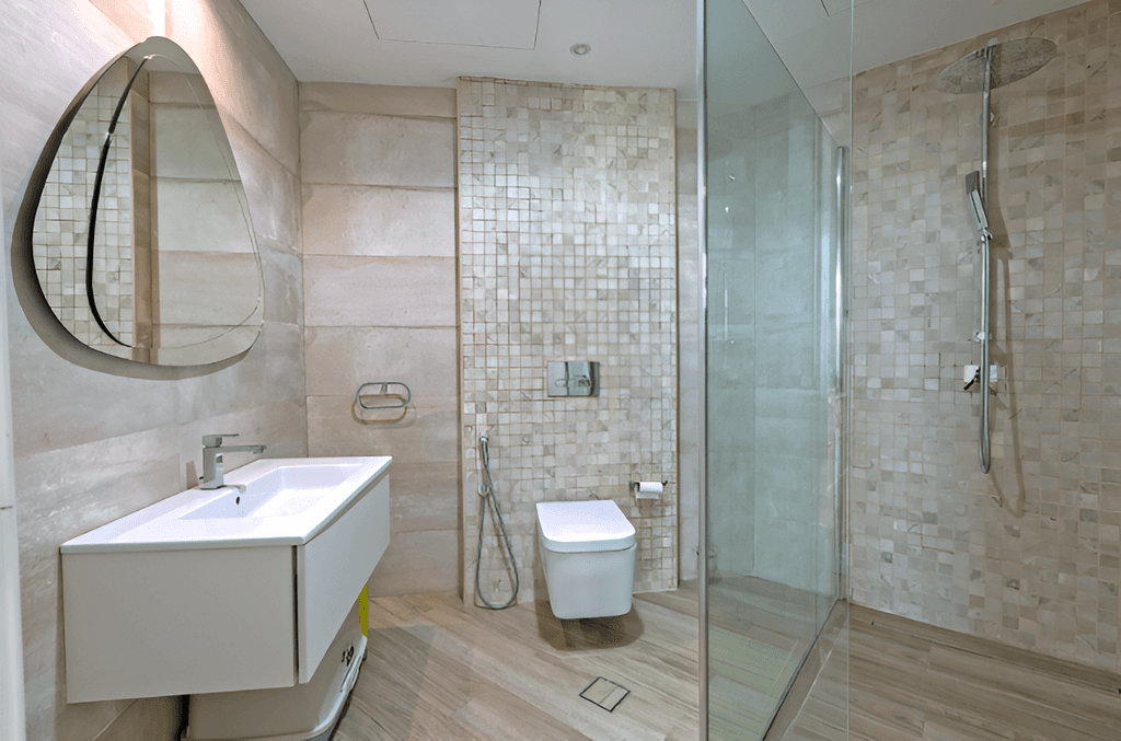 A bathroom in Shoreline Apartments featuring a glass shower door and a toilet.