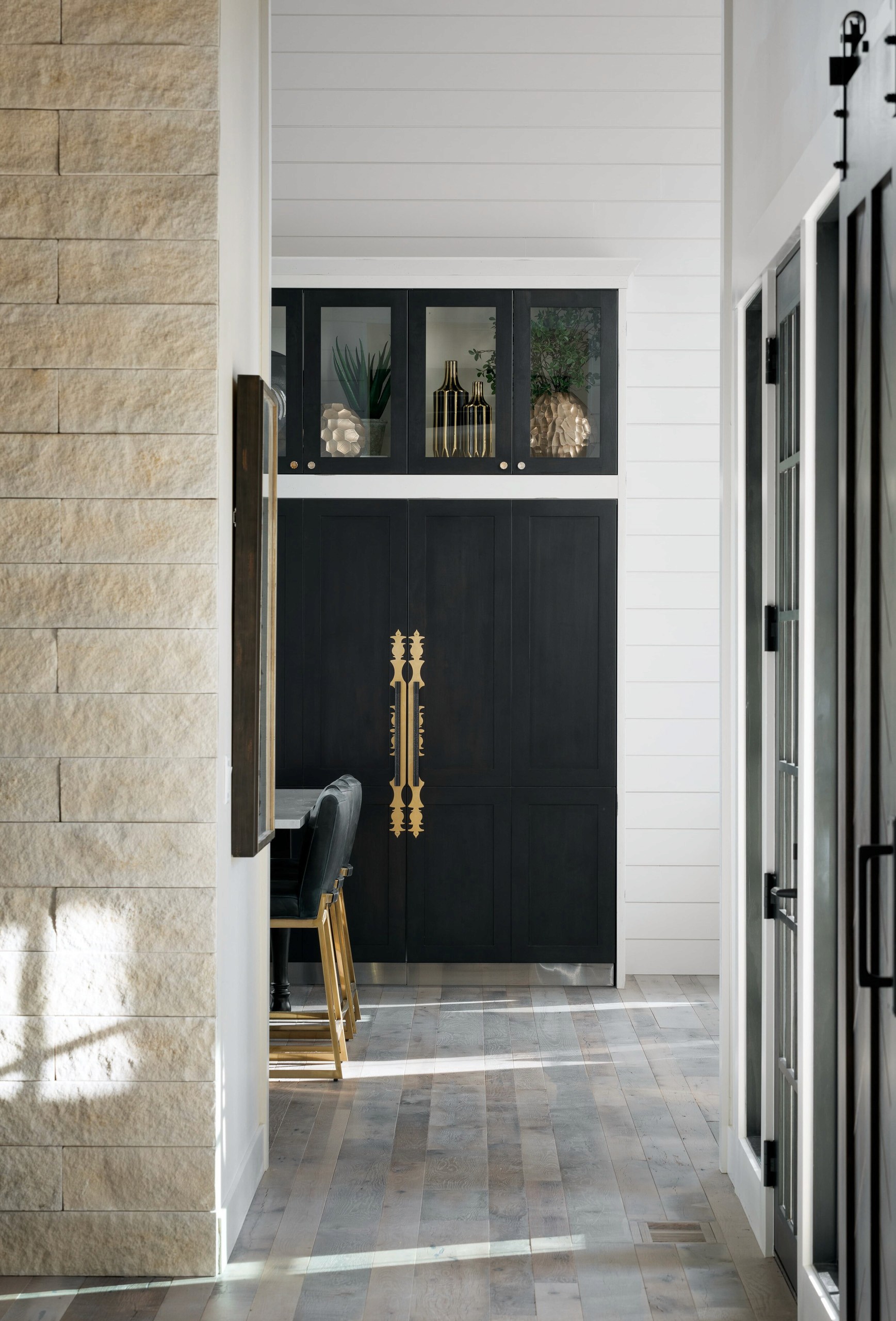 Modern entryway with dark cabinets and gold hardware.