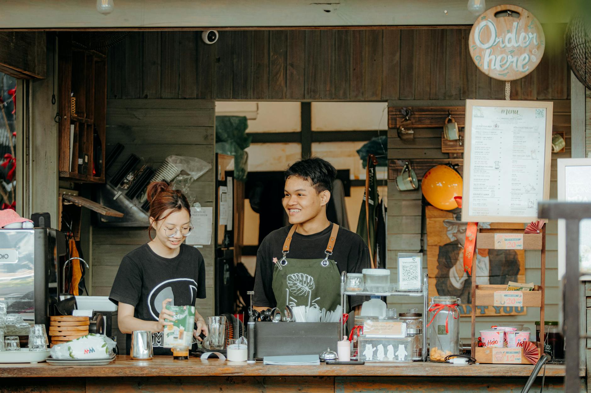 Echipă de baristas la counterul unei cafenele, atmosferă de lucru