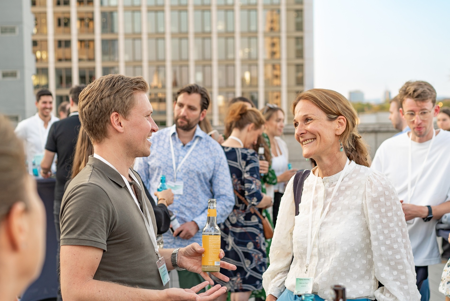 Drei Geschäftspersonen stehen an einem Tisch und blicken in die Kamera