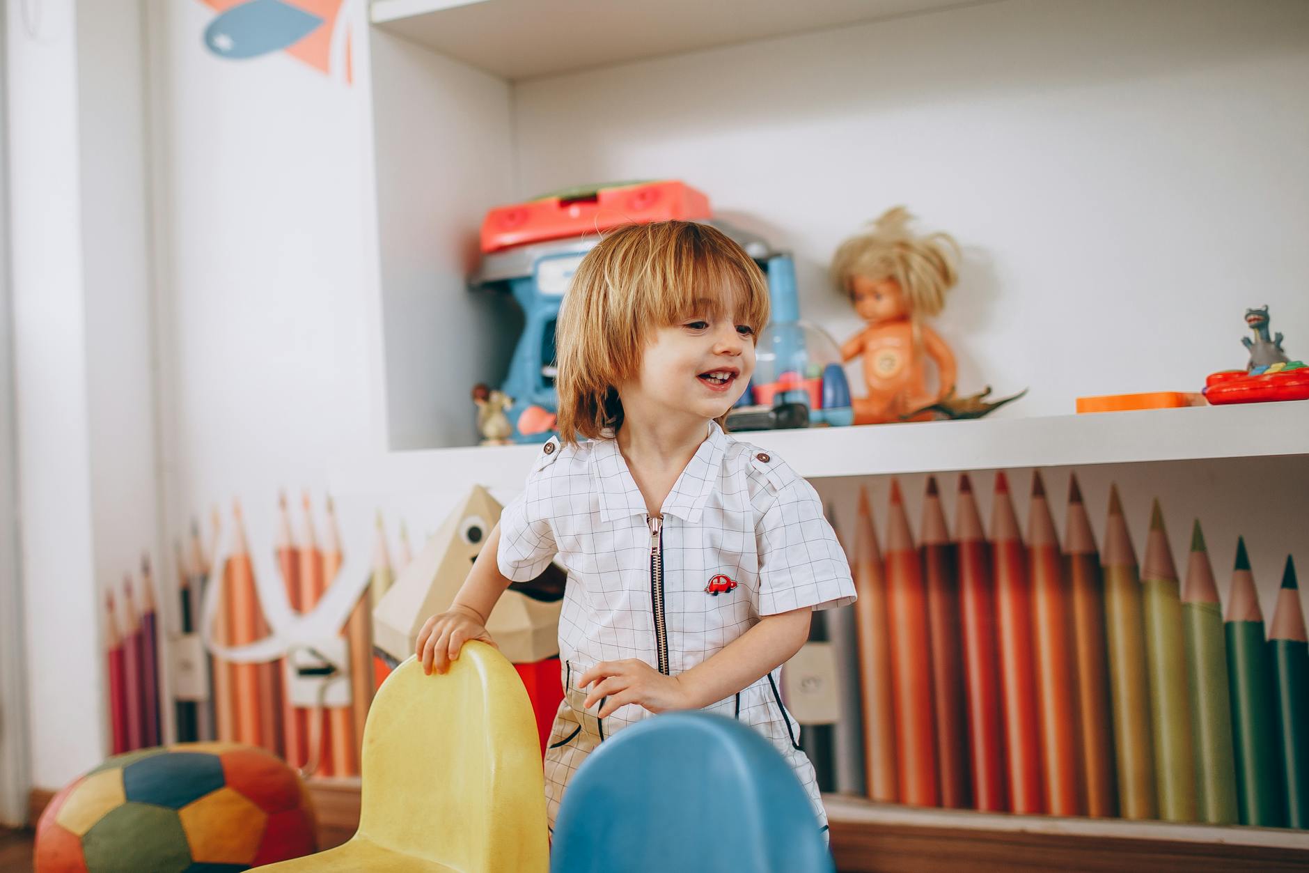 Close-up of a smiling child holding up a trophy made of building blocks after playing pre k math games.