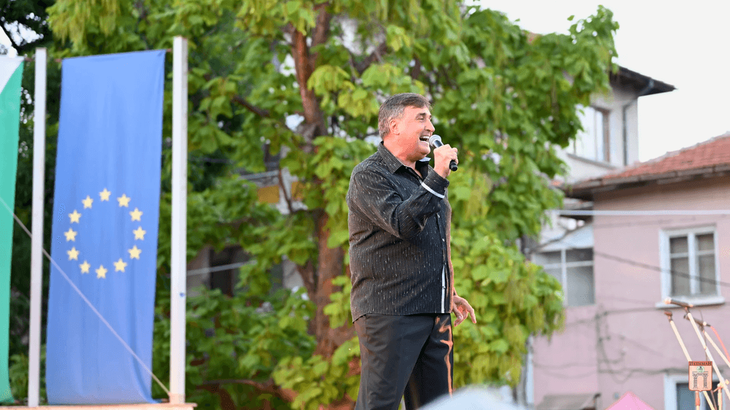 A man sings in front of the European Union flag