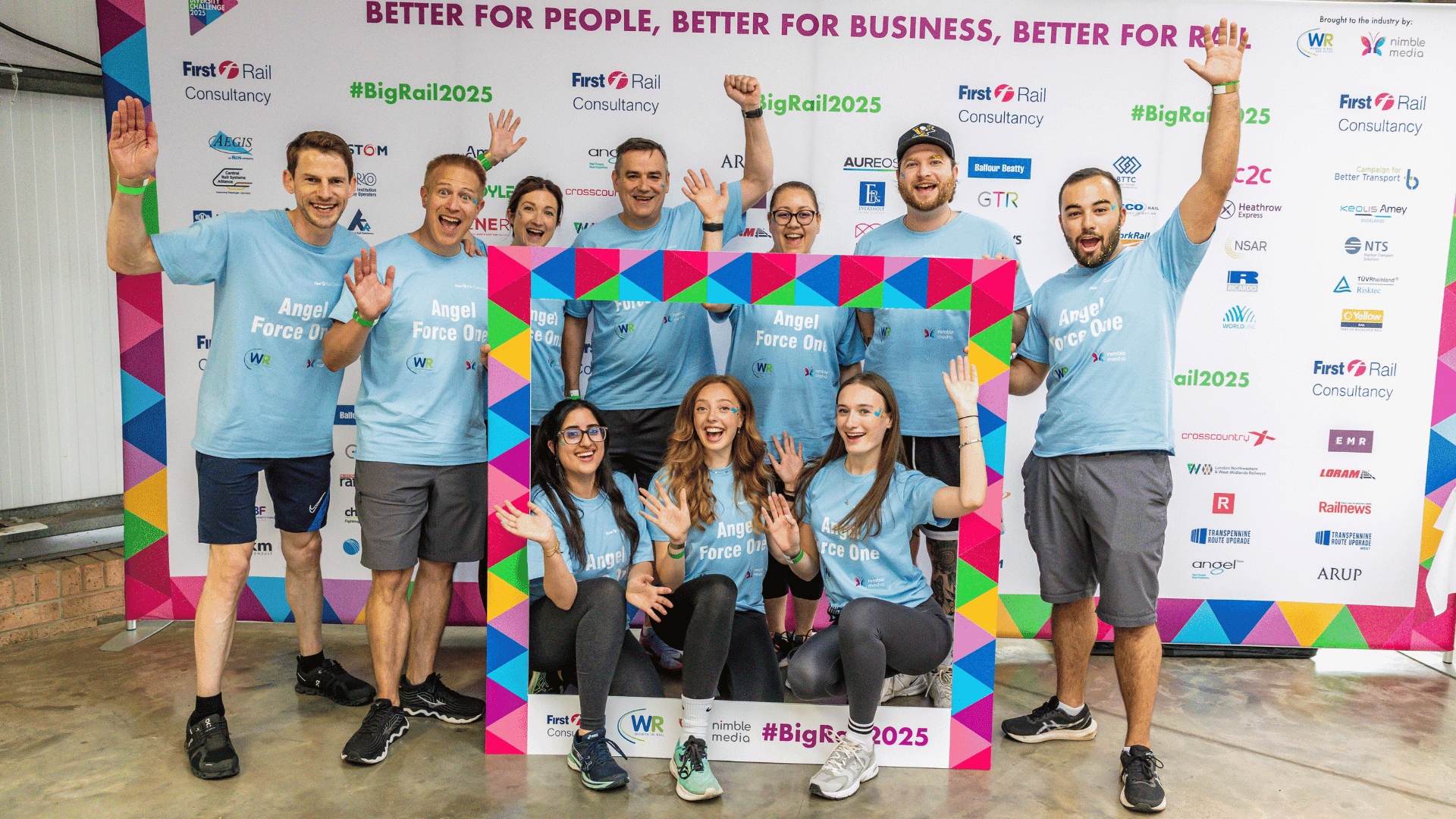 Outdoor team-building event with participants wearing matching blue shirts, taking part in inflatable obstacle courses and games, smiling and cheering, with the words 'ENTER A TEAM' in large bold white and green text across the image.
