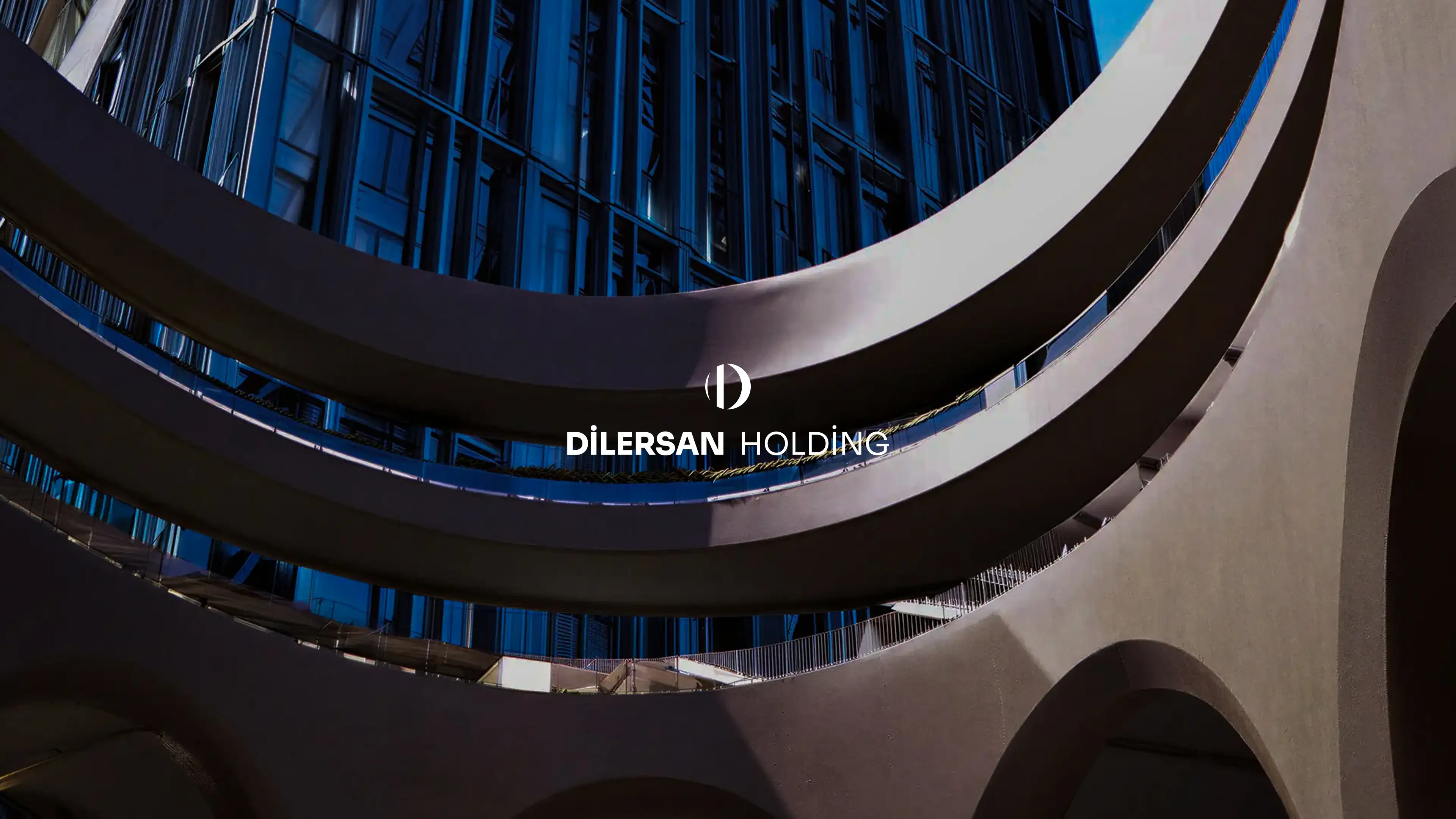 Official Dilersan Holding website hero image featuring cinematic blue-lit modern architecture and the white corporate wordmark.