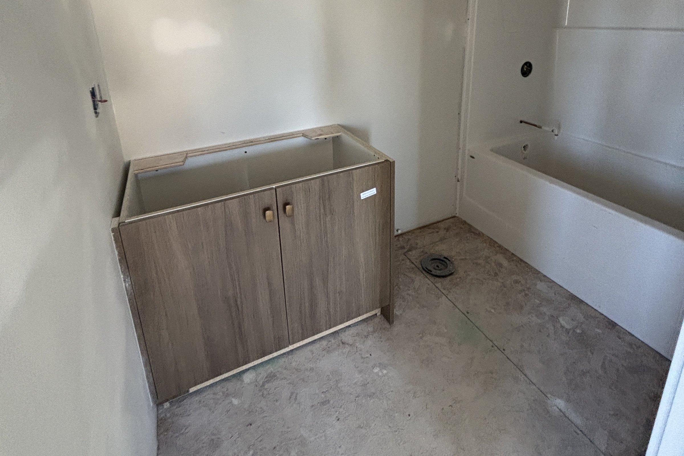 Heartland second bathroom during construction: vanity cabinet and tub, unfinished