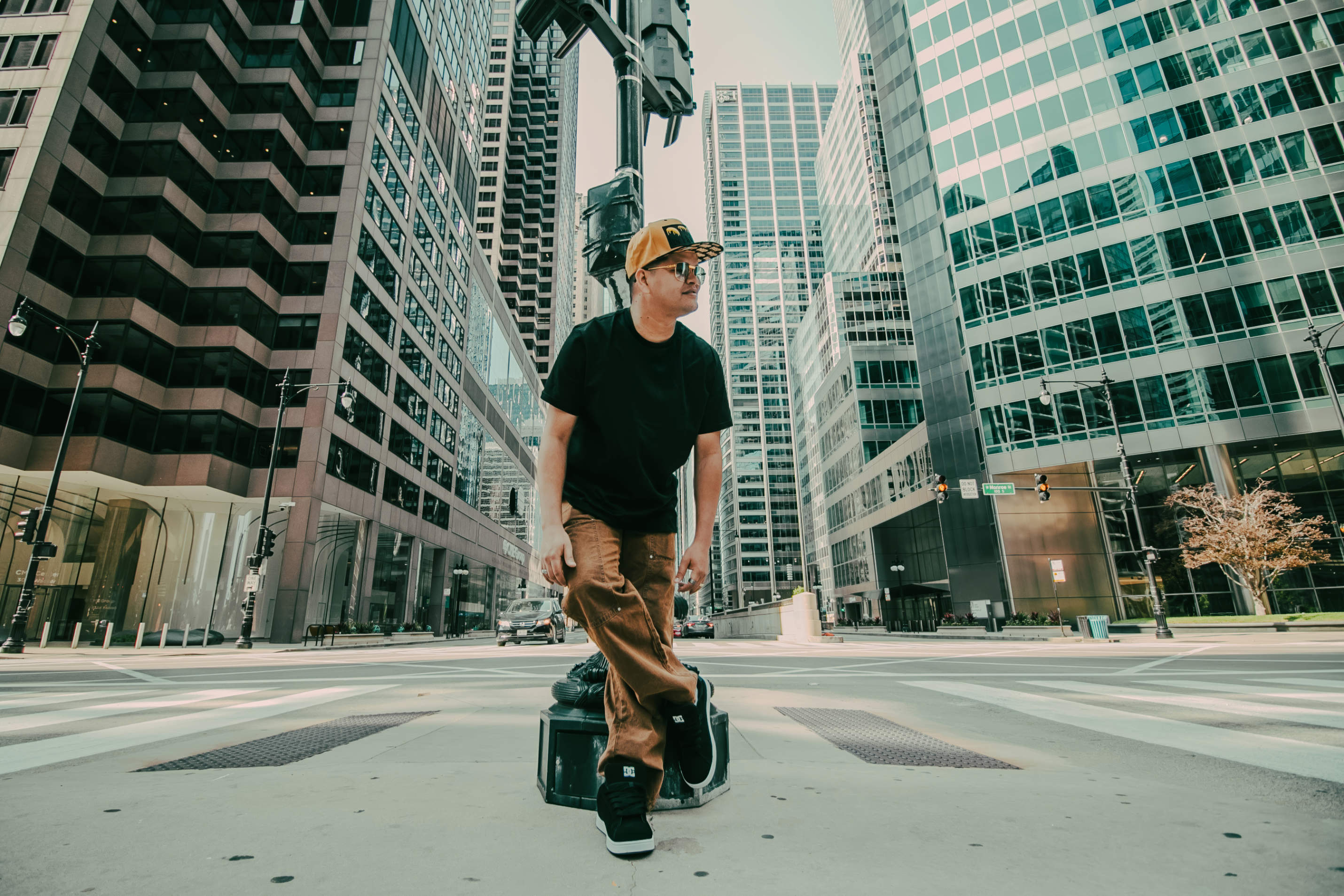 Dani Sierra stands in an urban environment, surrounded by tall buildings and a clear sky.