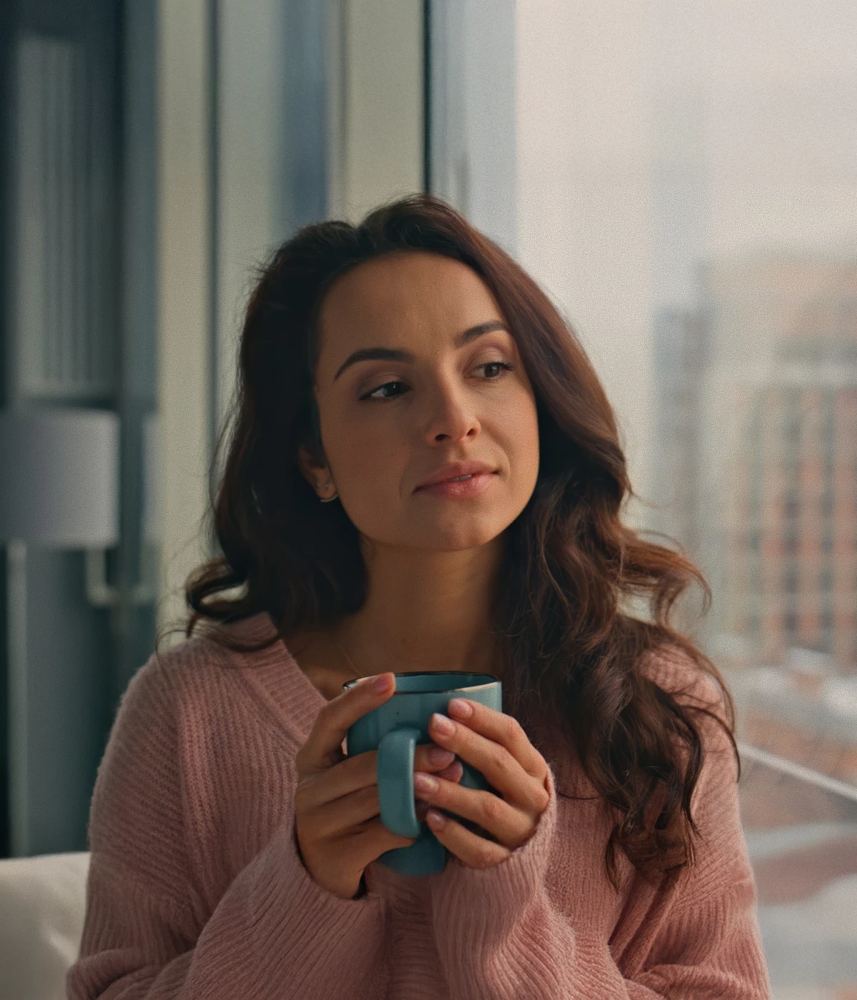 Woman relaxing outdoors with an old mobile phone placed beside her.