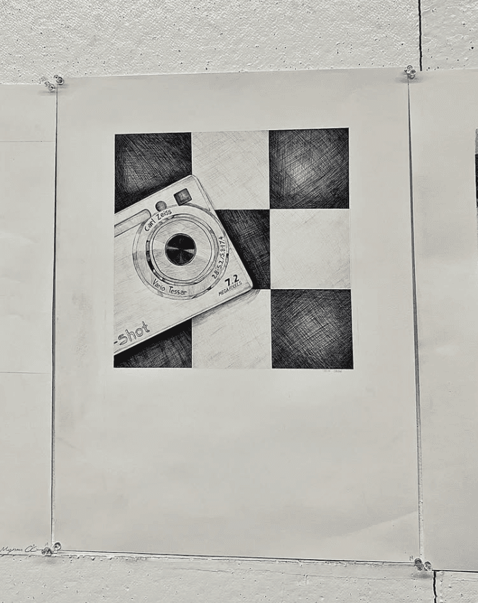 Black and white drawing of a digital camera pinned to a wall