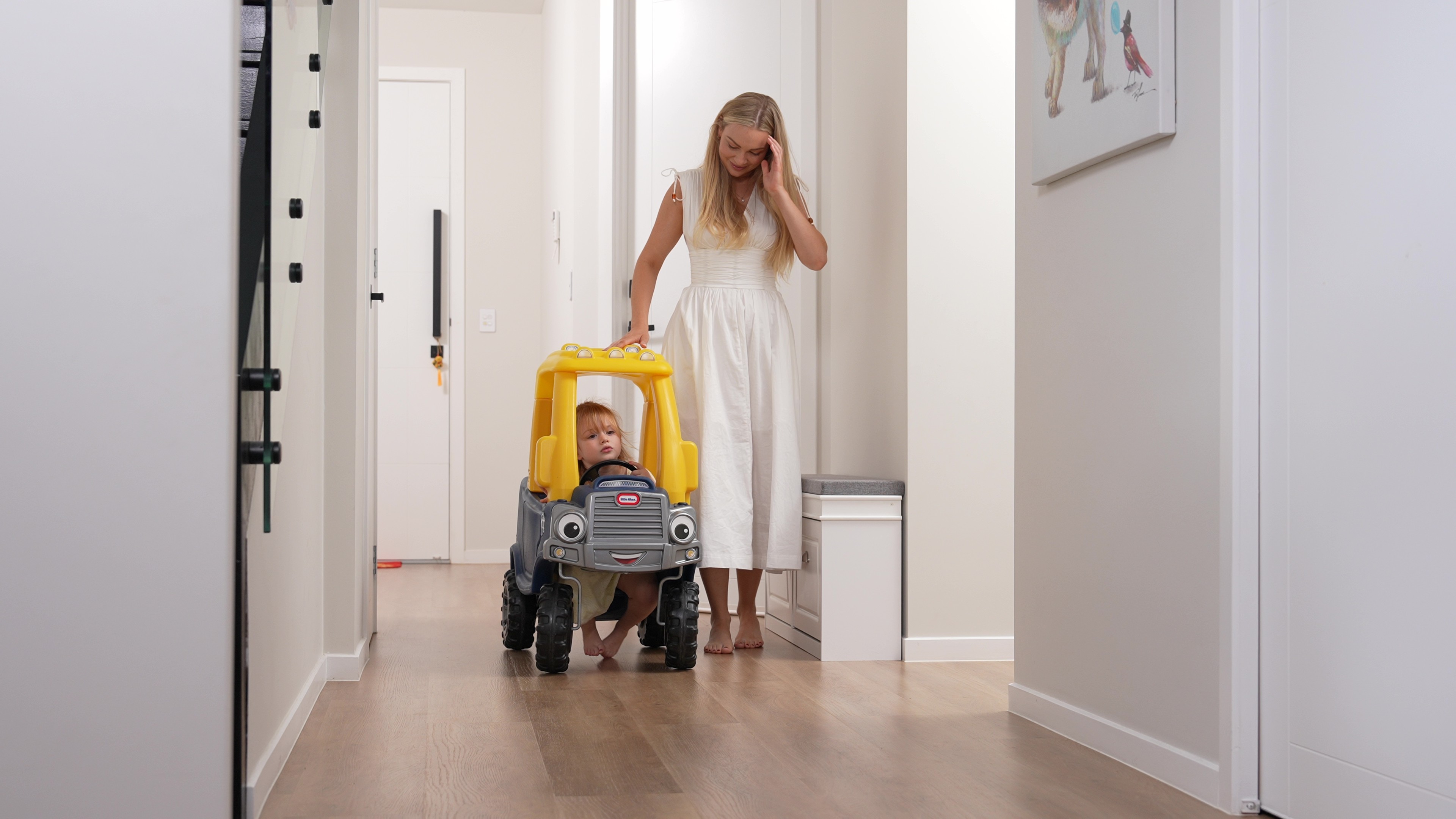 Parent pushing a child in a toy truck along hybrid flooring, showing a smooth, durable surface made for active family homes across Queensland.