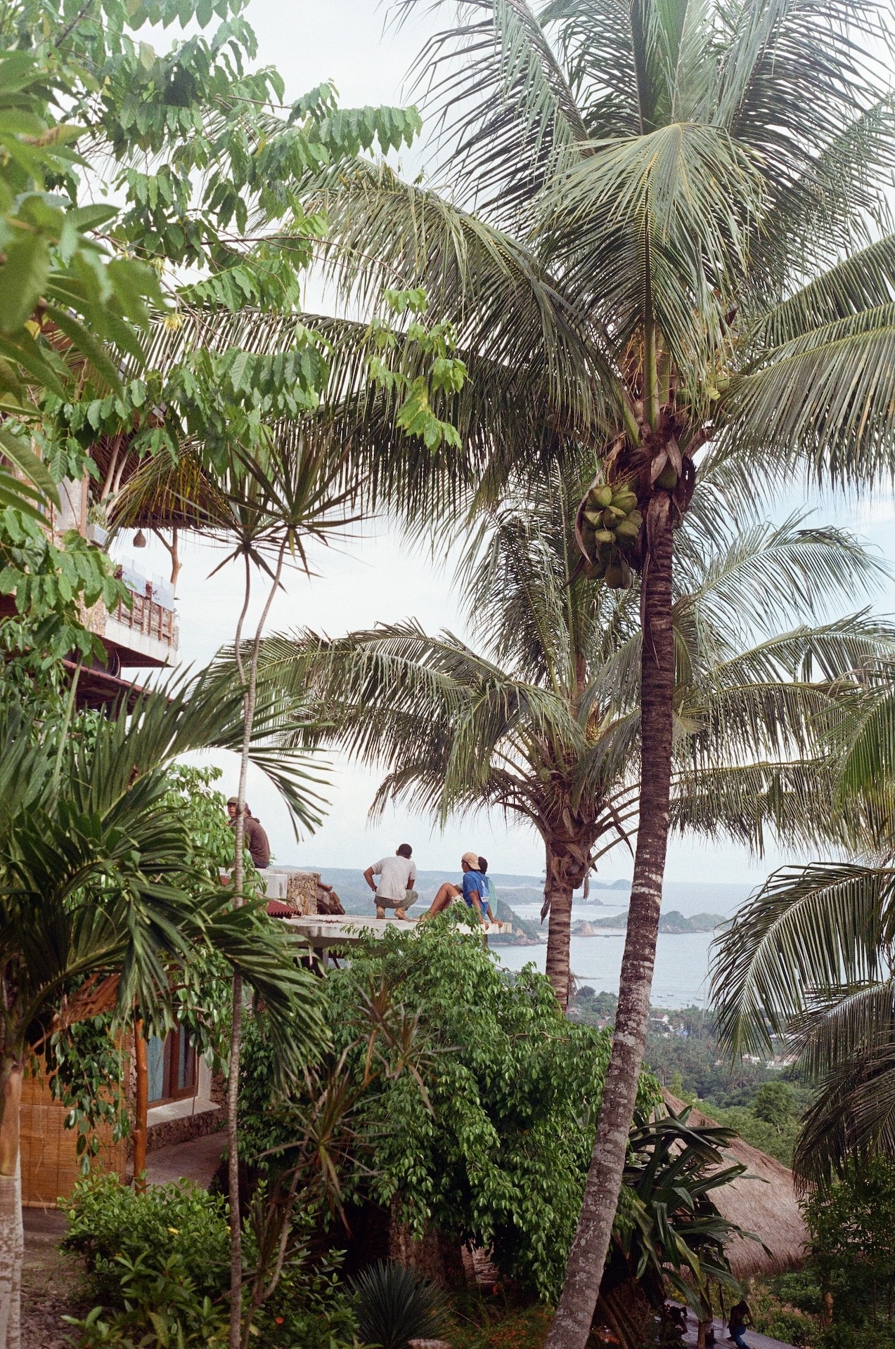 Film photo of Indonesian people working on the edge of a cliff with a breathtaking ocean view in Uluwatu, Bali 